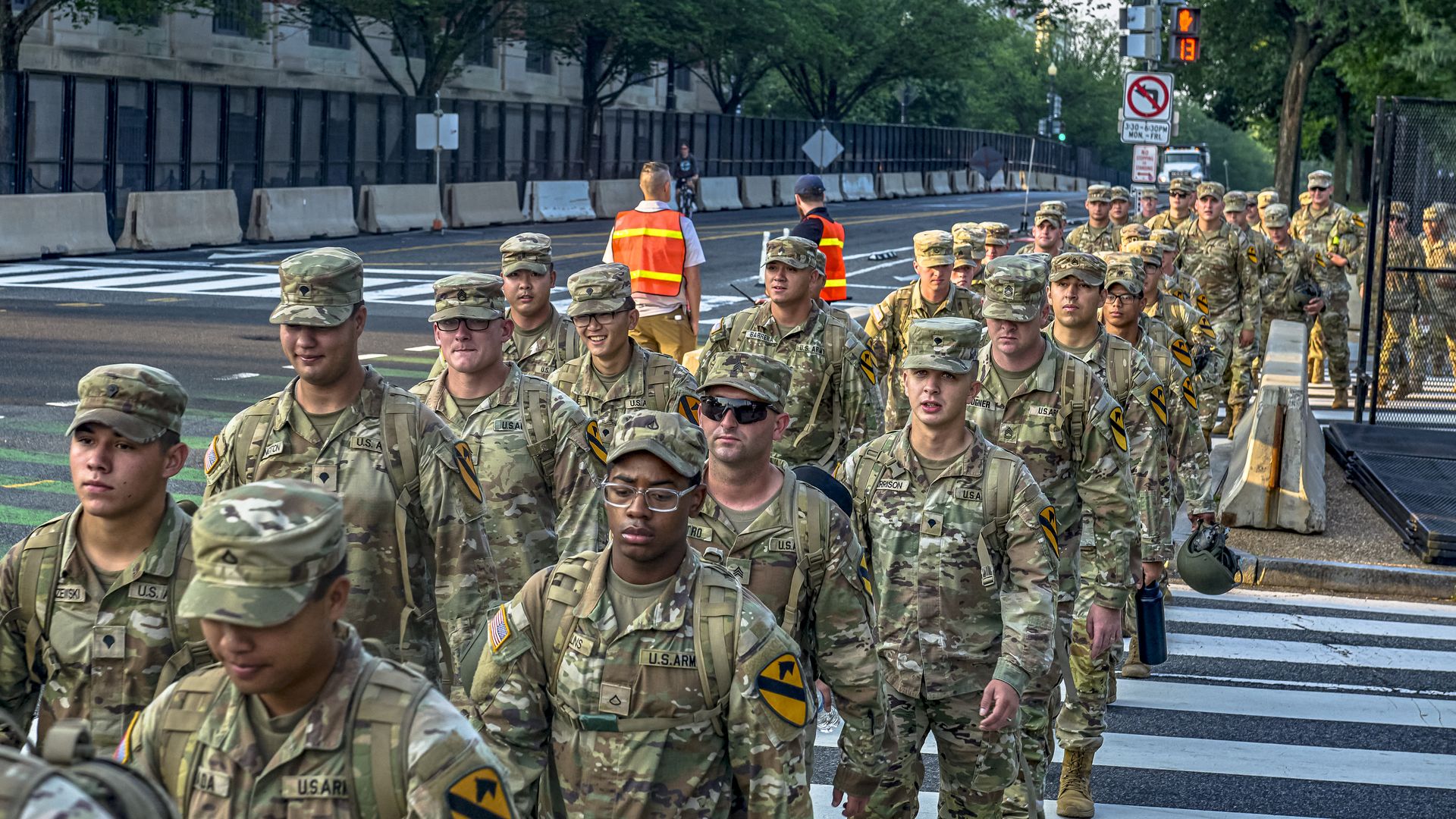Soldiers in Army uniforms walk on D.C. street in advance of military parade