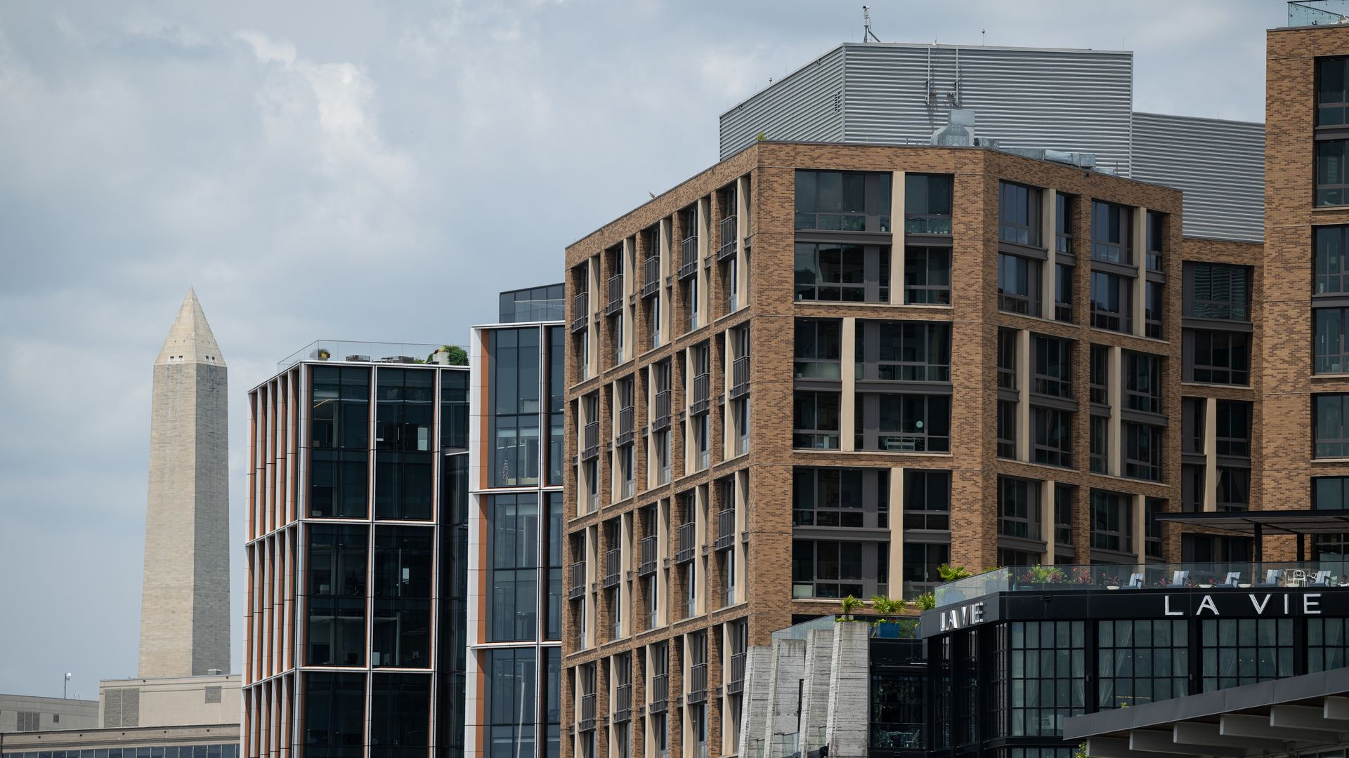 A picture of buildings at the Wharf in D.C., with the Washington Monument in the background