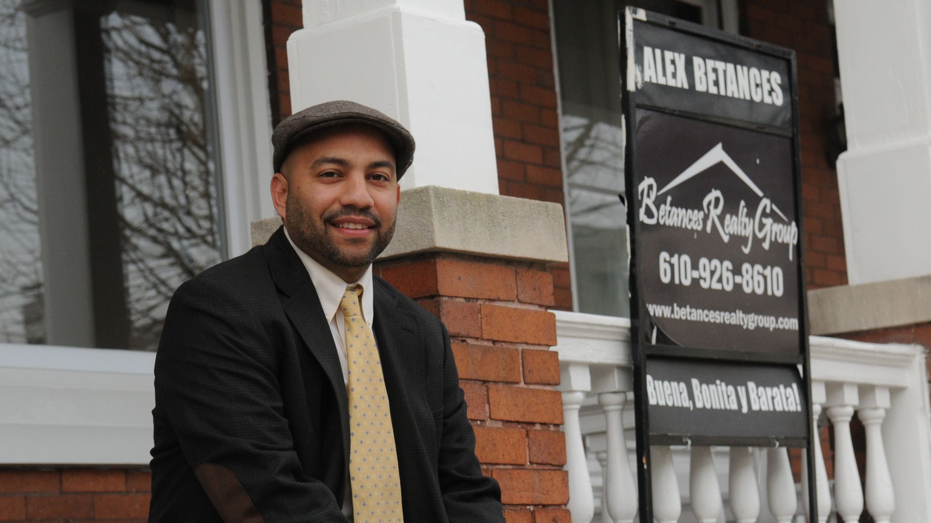 Real estate broker Alex Betances sits in front of a home ion Reading, Penn.