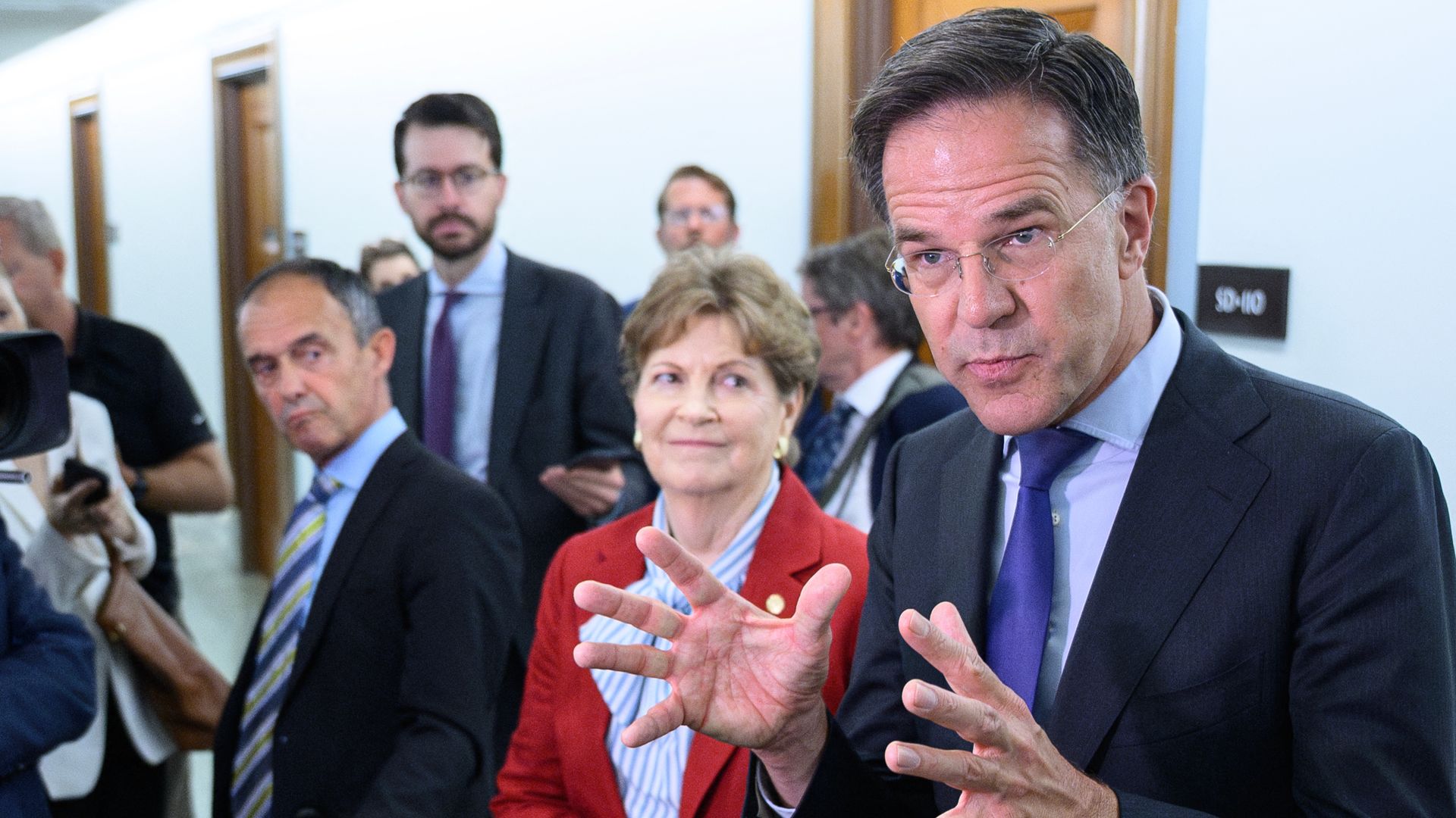 Mark Rutte talks with his hand. Jeanne Shaheen smiles on