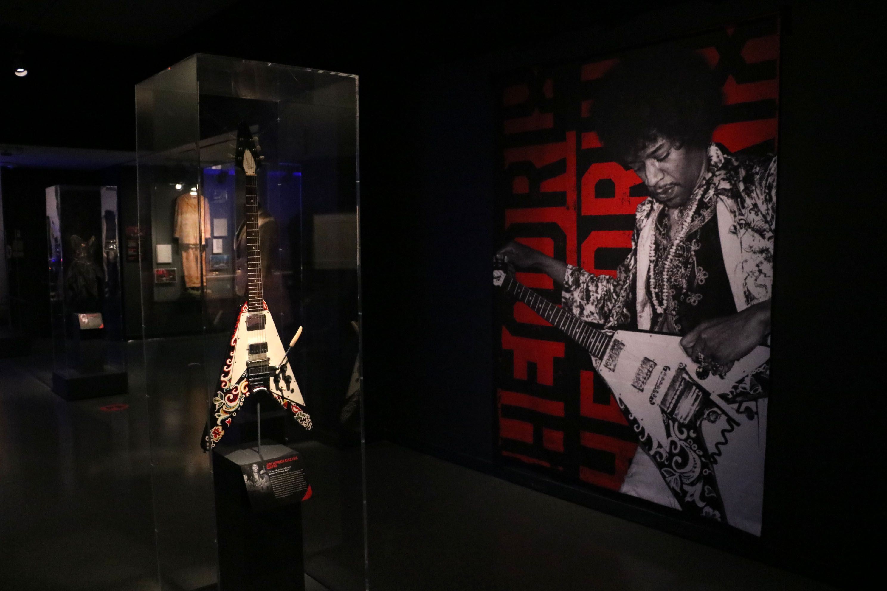 Jimmy Hendrix's Flying V guitar in a case inside a dark museum.