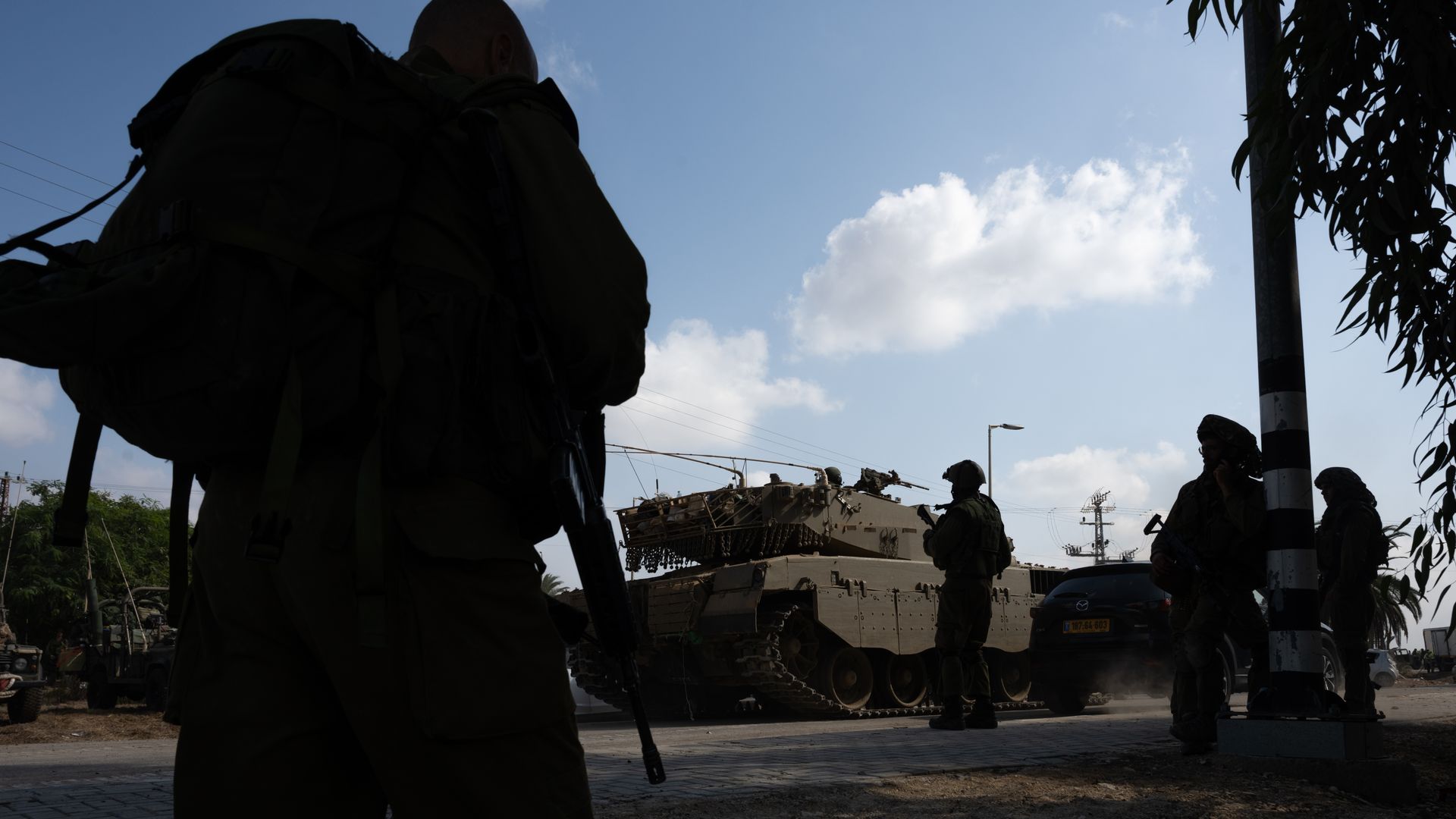 Soldiers walk past tanks moving outside of Kibbutz Kfar Aza where days earlier Hamas militants attacked this kibbutz near the border with Gaza, on October 10, 2023 in Kfar Aza, Israel. 