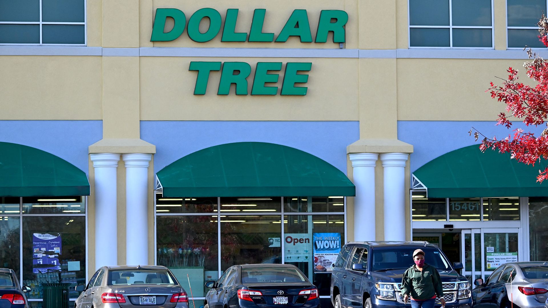 Photo of a person walking in the parking lot outside a Dollar Tree store 