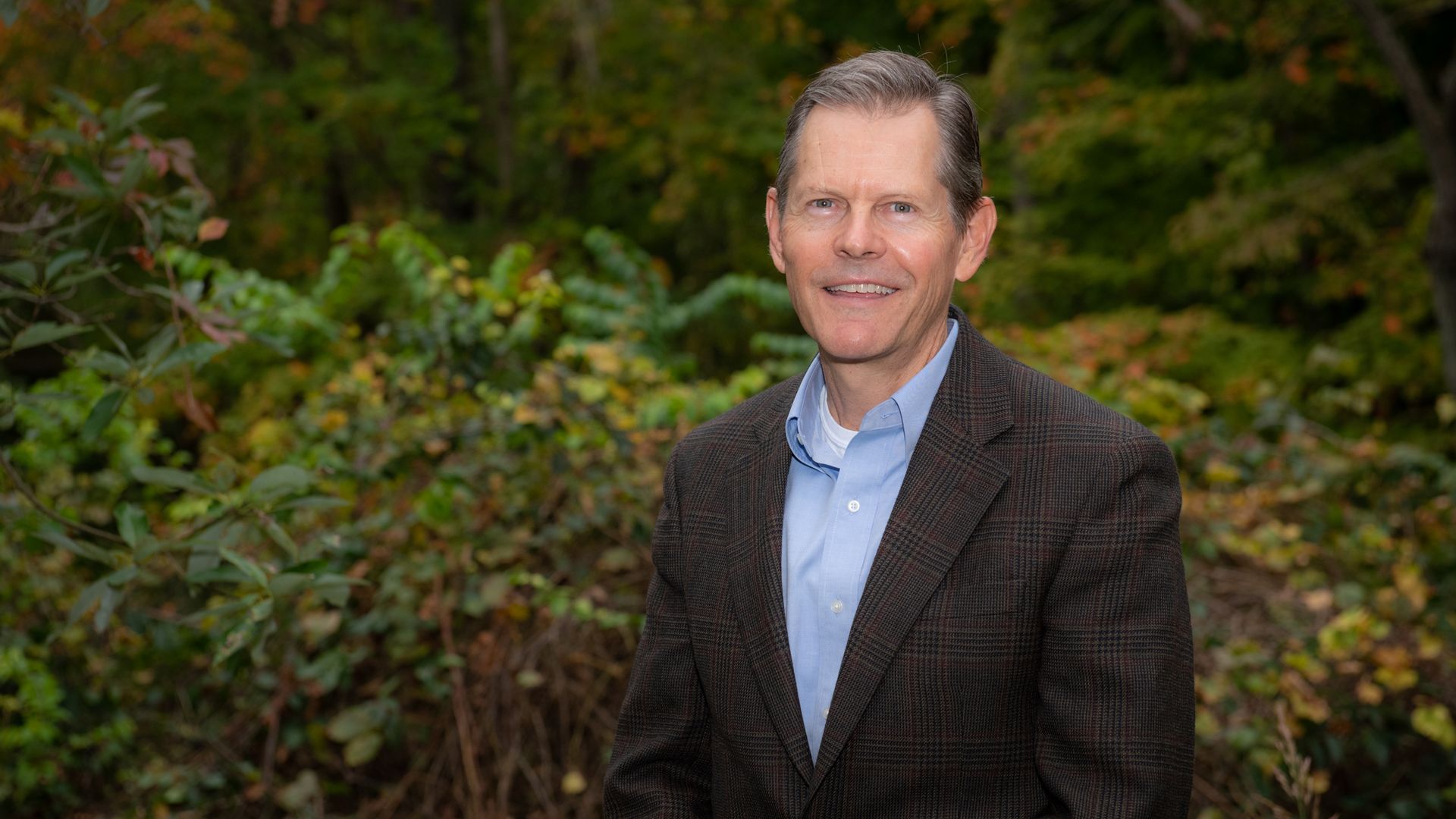 New Columbus Zoo and Aquarium president and CEO Tom Schmid stands in front of trees for a headshot photo