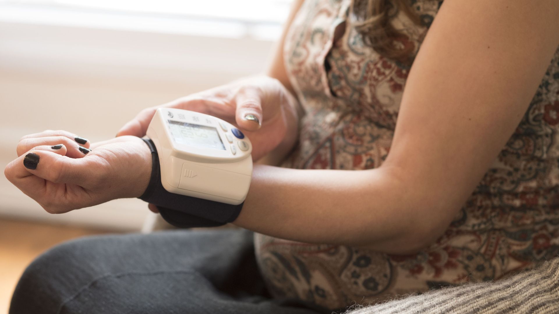 A woman takes her blood pressure.