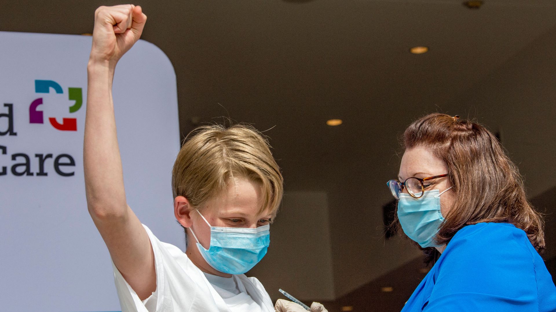 A 13 year old kid pumps his fist after getting vaccinated