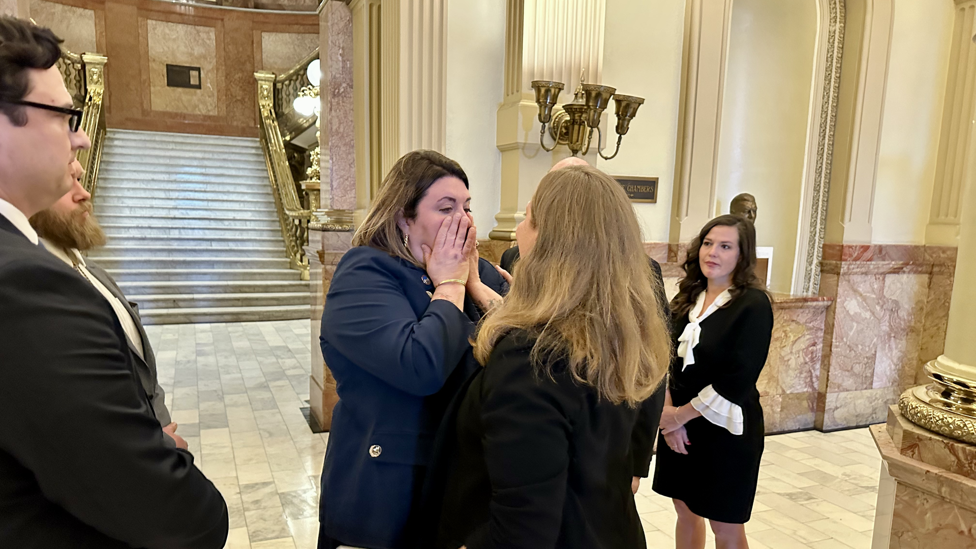 State Rep. Jenny Willford, center, wipes away tears as she's comforted by her attorney, center right, Morgan Carroll. Photo: John Frank/Axios