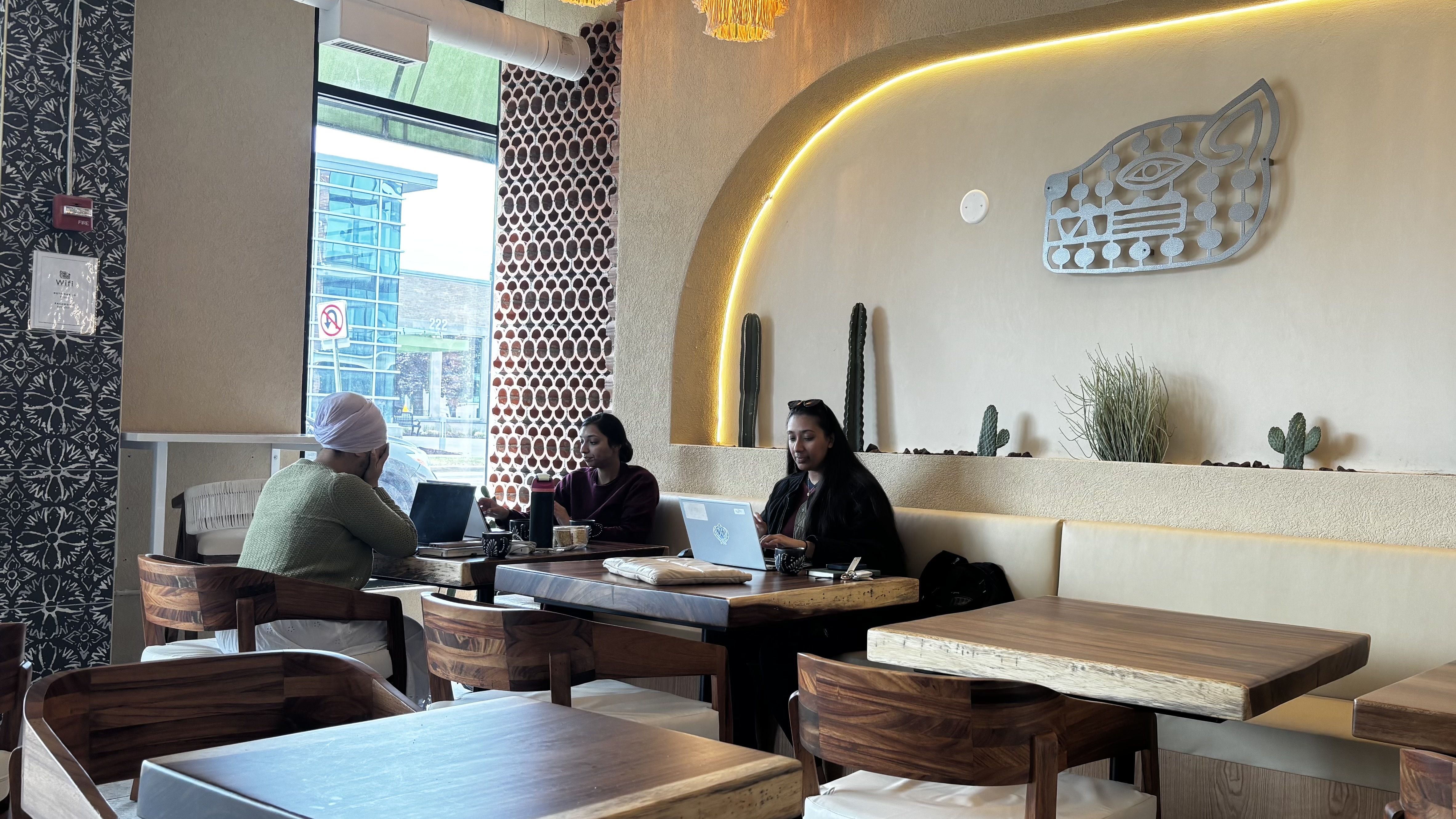 Customers seated at a table inside Balam Coffee & Wine in Ferndale.
