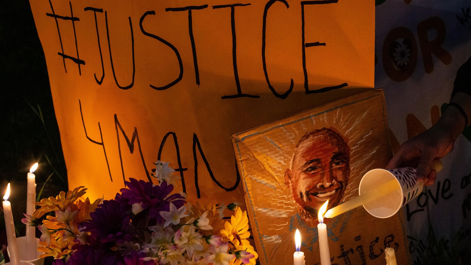 A person lights a candle at a vigil for Manuel Ellis, a black man whose March death while in Tacoma Police custody was recently found to be a homicide, according to the Pierce County Medical Examiners Office, on June 3, 2020 in Tacoma, Washington. 