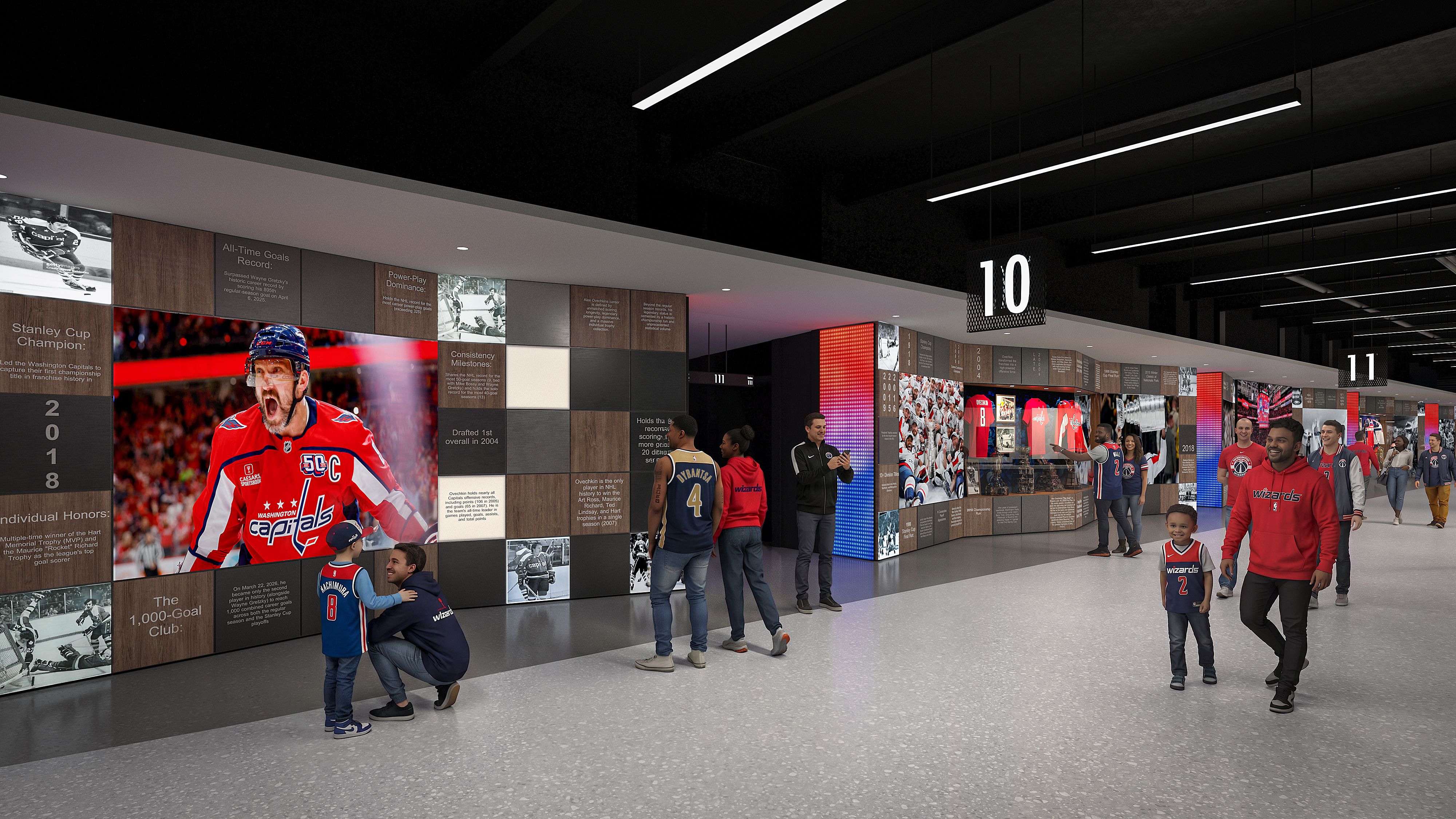 Museum hallway with wall-panelled exhibits featuring photos and text, oversized 10 and 11 signs, visitors in Wizards jerseys, a large Washington Capitals hockey image on the left, black ceiling lights