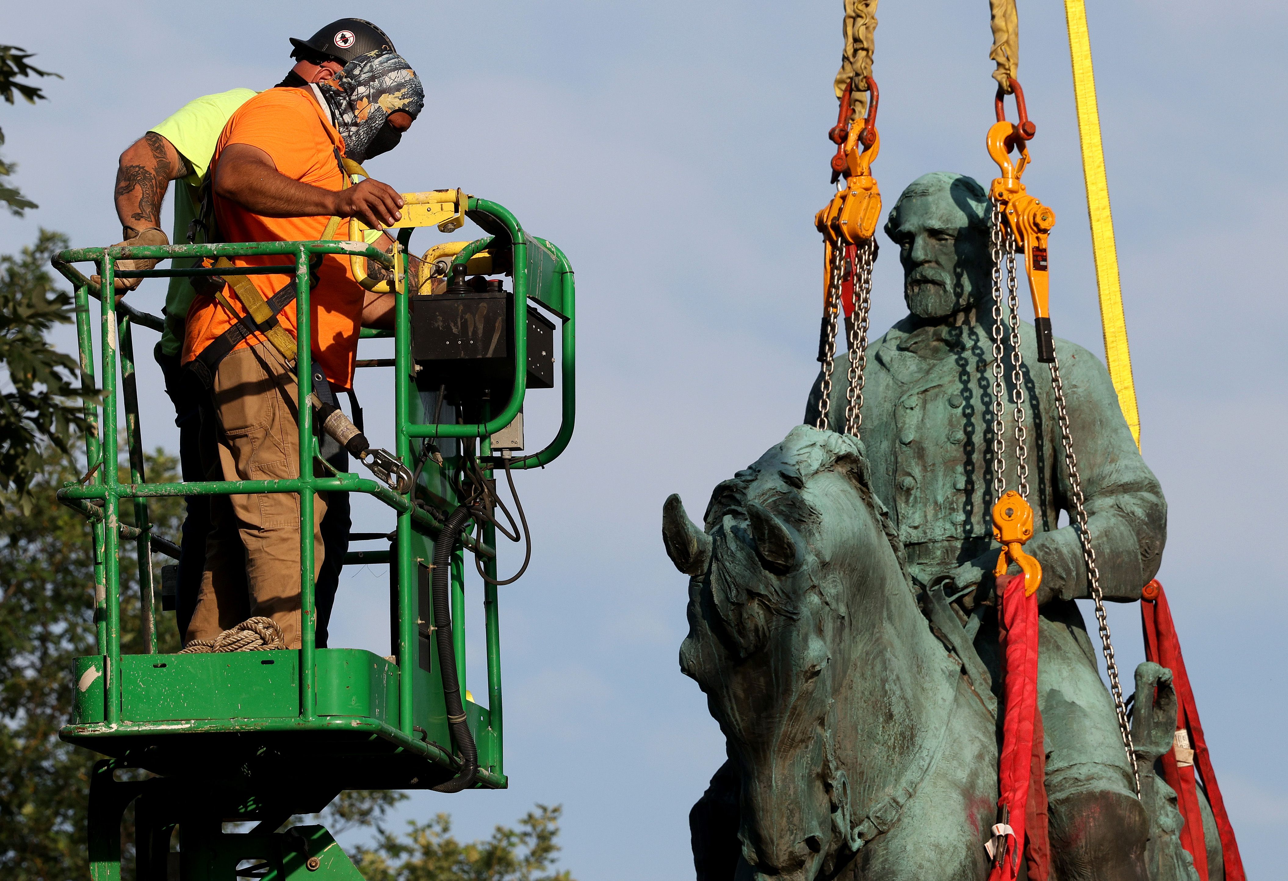 Workers remove a statue of Confederate General Robert E. Lee from Market Street Park July 10