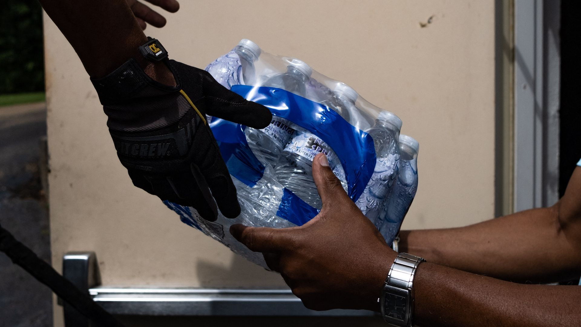 Photo of people handing water bottles to each other