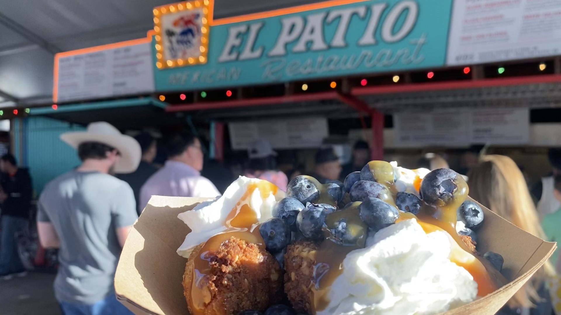 Photo of three cake calls with whipped cream and blueberries in front of a booth named El Patio