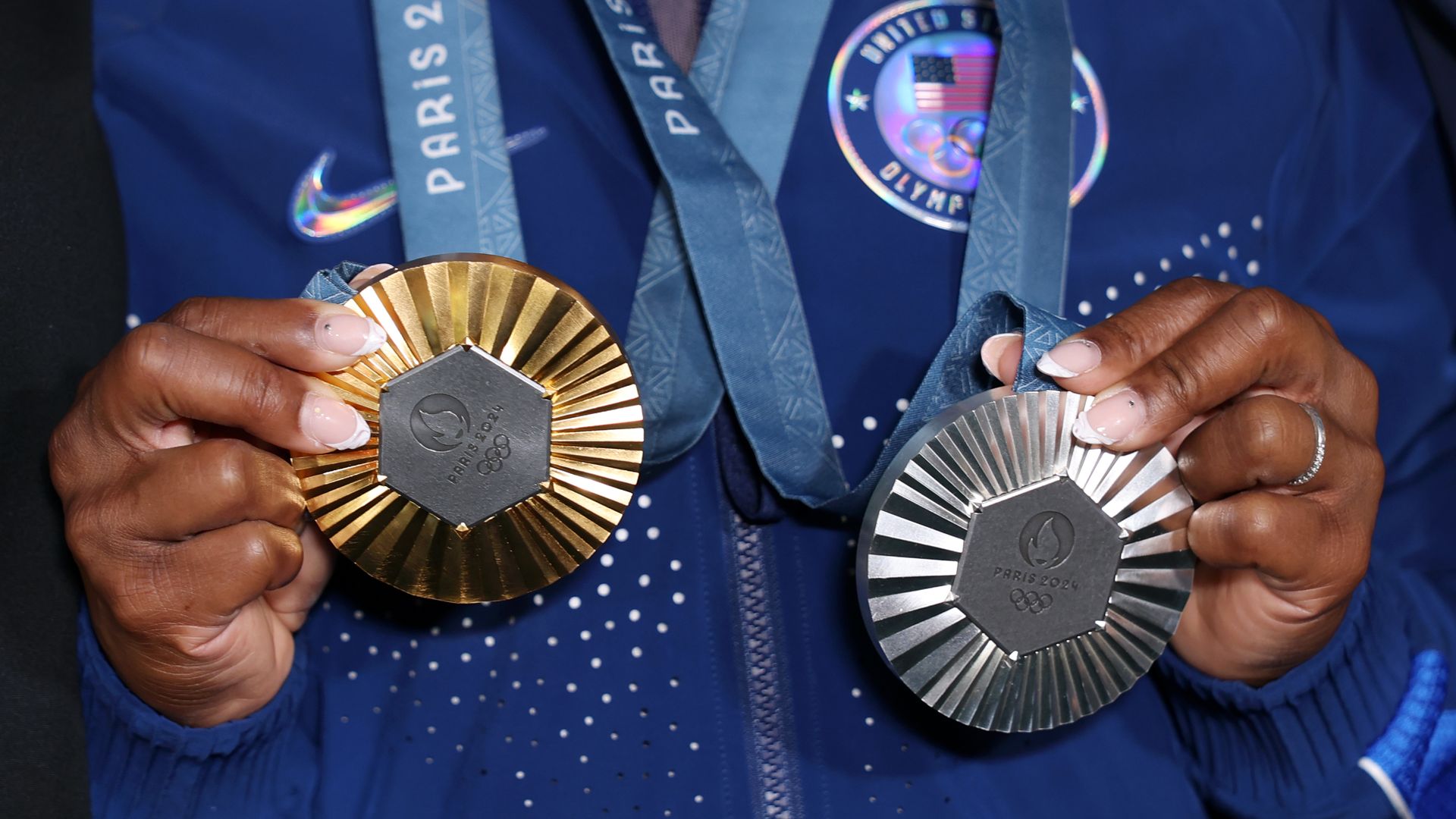 Simone Biles holds two medals around her neck