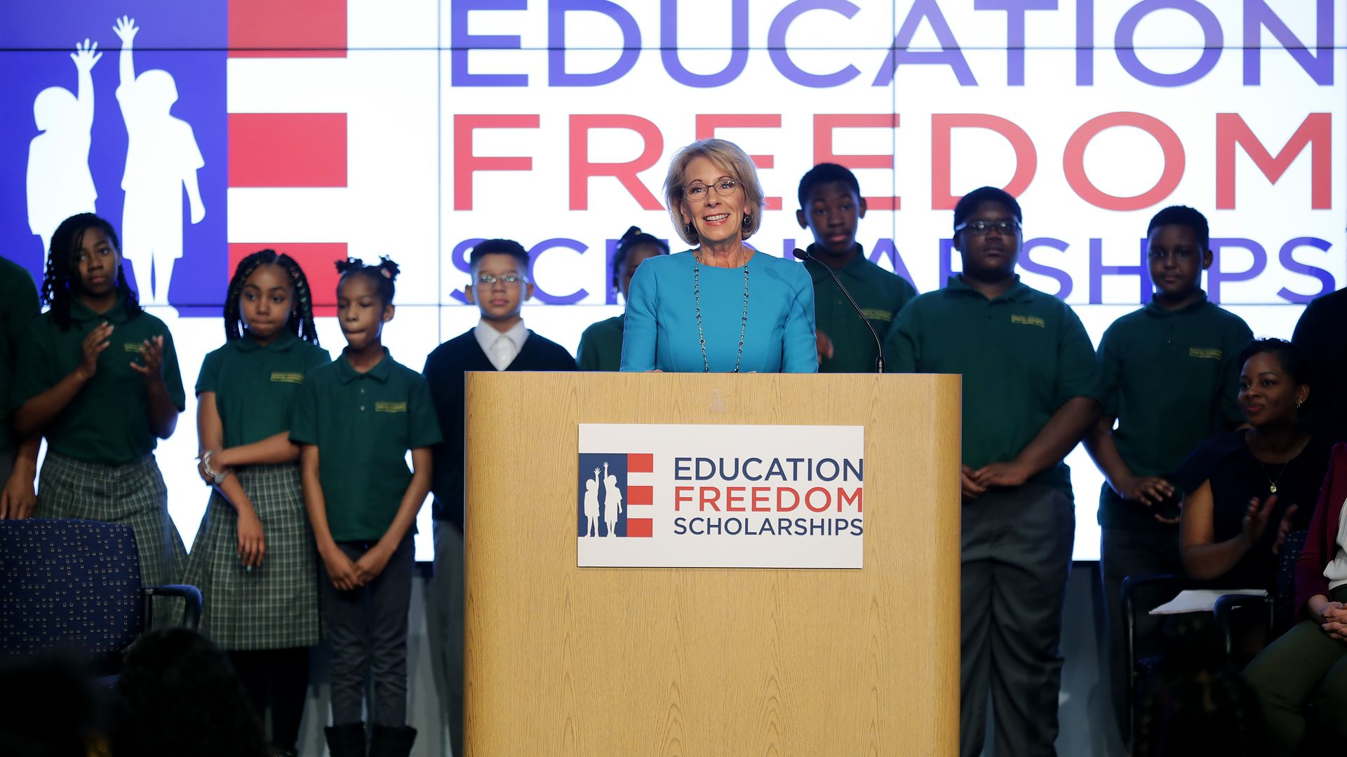 Betsy devos behind a podium