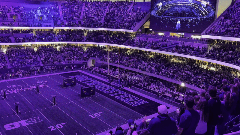 A GIF of a stadium with its lights flashing as players run onto the field. 