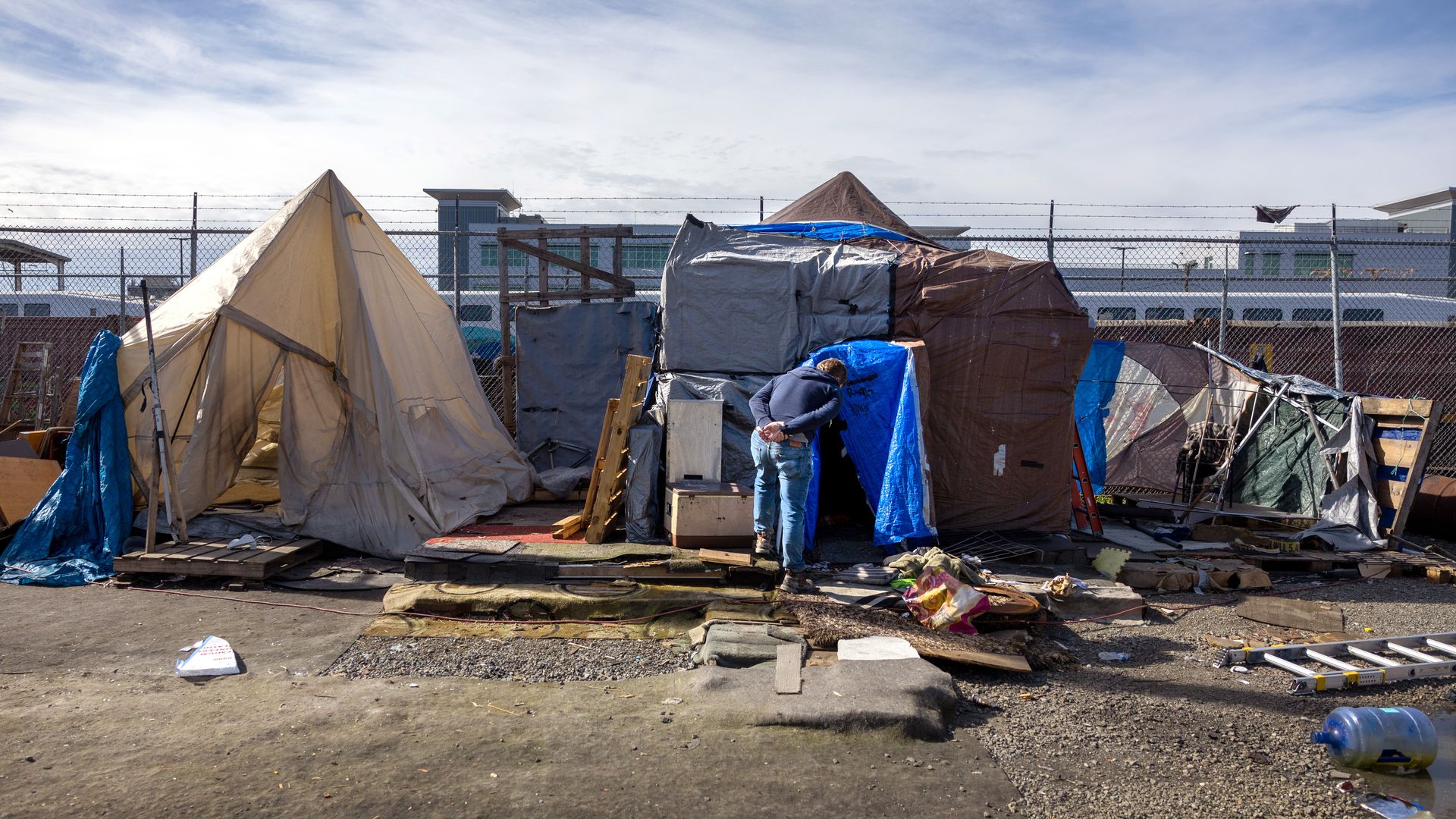 Tents in front of a fence.