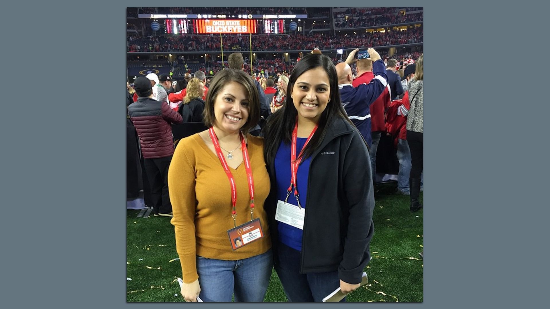Naheed and Tasha stand on a football field with a crowd in the background. A stadium scoreboard reads "Ohio State Buckeyes."