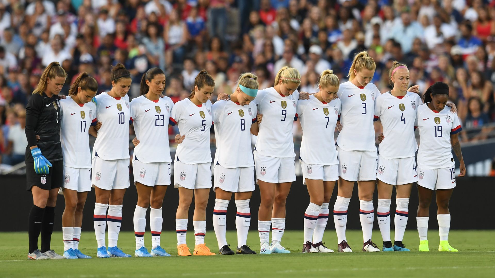 USWNT standing on the field together