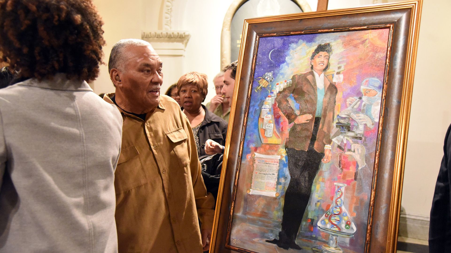 Man in brown shirt looks at painting