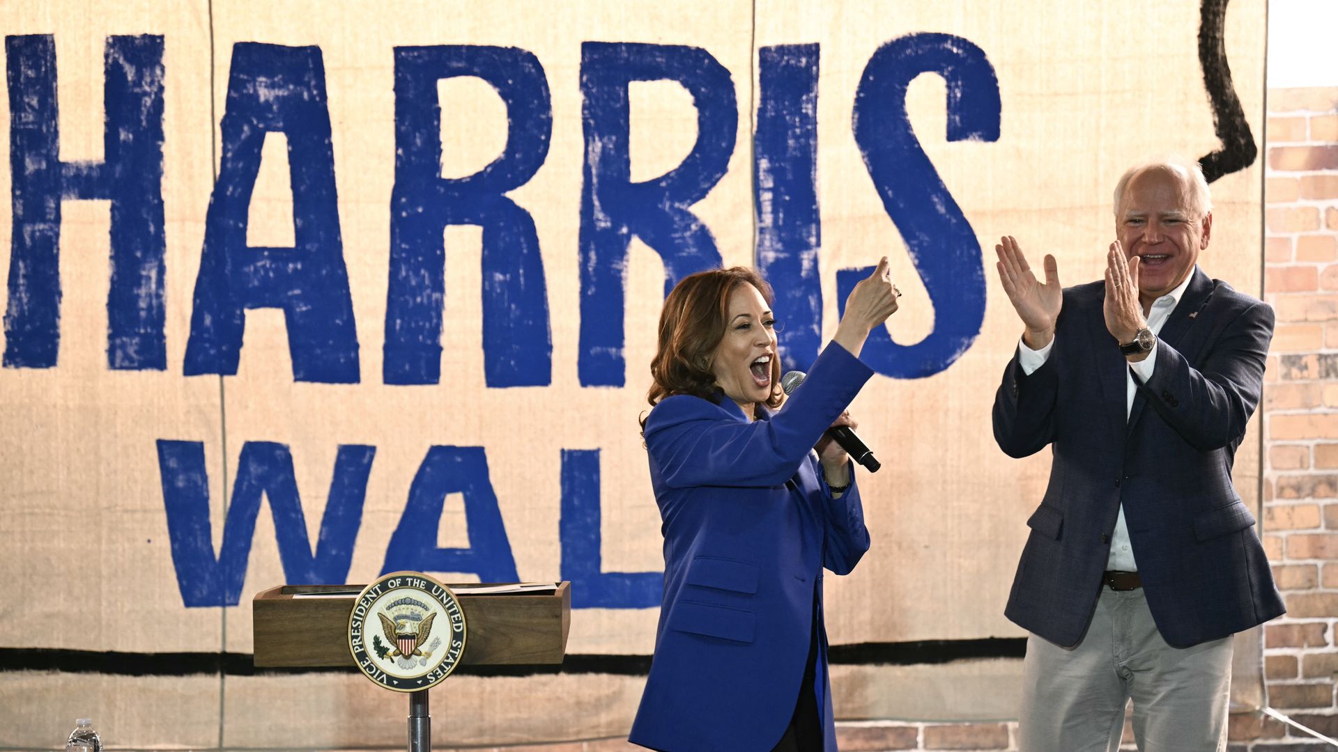Vice President Kamala Harris points to her running mate, Minnesota Gov. Tim Walz, during a stop on their campaign bus tour in Rochester, Pa., on Sunday.