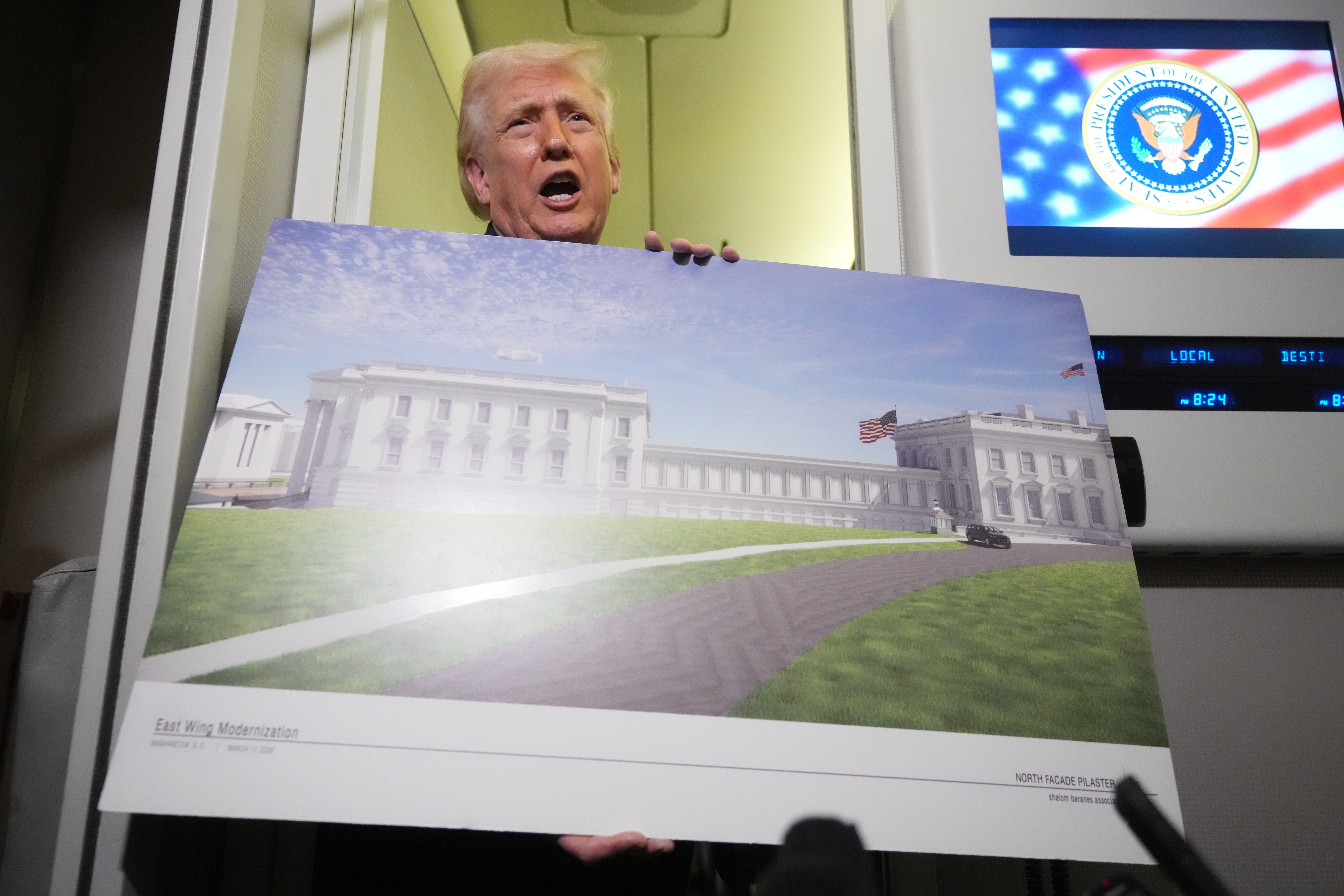 President Donald Trump holds a rendering of the proposed new East Wing of the White House as he speaks to reporters aboard Air Force One en route from West Palm Beach, Fla., to Joint Base Andrews, Md., Sunday, March 29, 2026. (AP Photo/Mark Schiefelbein