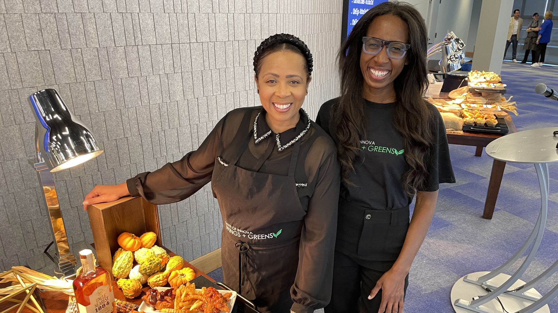 Monique Hawkins and daughter Kara Hawkins pose in front of wings they'll be selling this season at Indiana Pacers games.