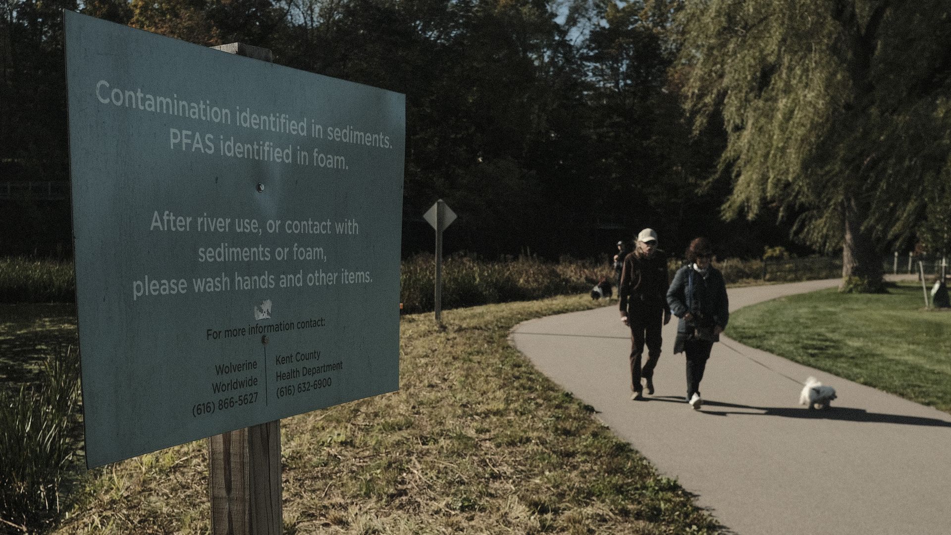 A sign warning people of PFAS contamination in the Rogue River in Rockford, Michigan, in October 2021.