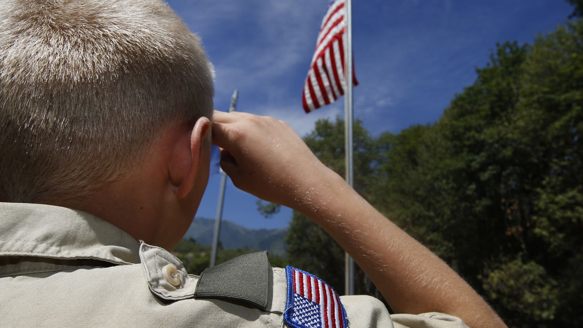 A Boy Scout salutes the American flag at camp Maple Dell.