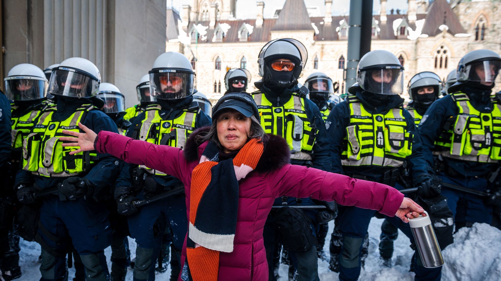 A demonstrator blocks police as they deploy to remove protesters on February 19, 2022, in Ottawa, Canada.