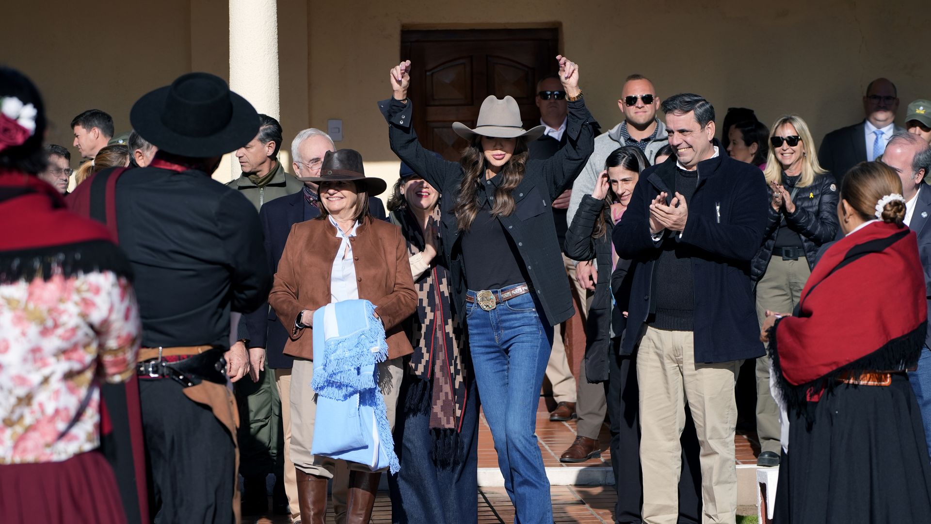Homeland Secretary Kristi Noem strikes a dance pose surrounded by Argentinian officials and gaucho dancers.