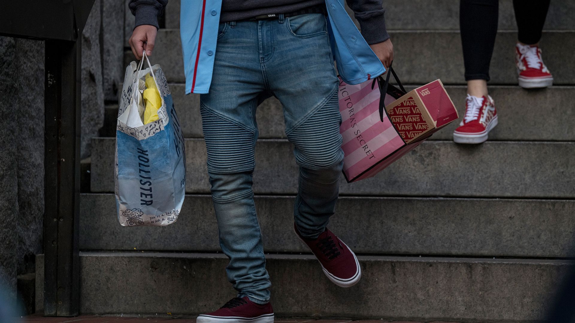 Shopper holding many shopping bags walking down steps