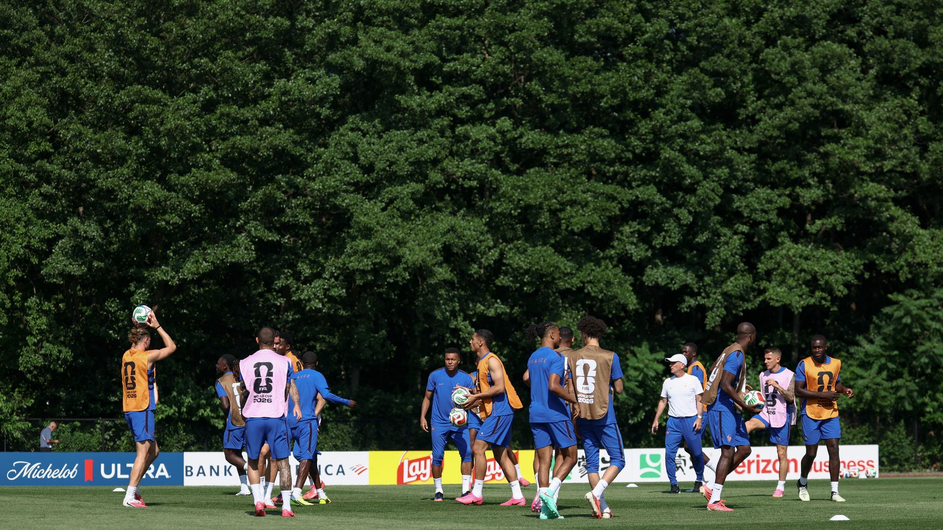 More than a dozen players from France's national soccer team practice at Bentley University in Waltham on July 8, 2026. Several are holding soccer balls.