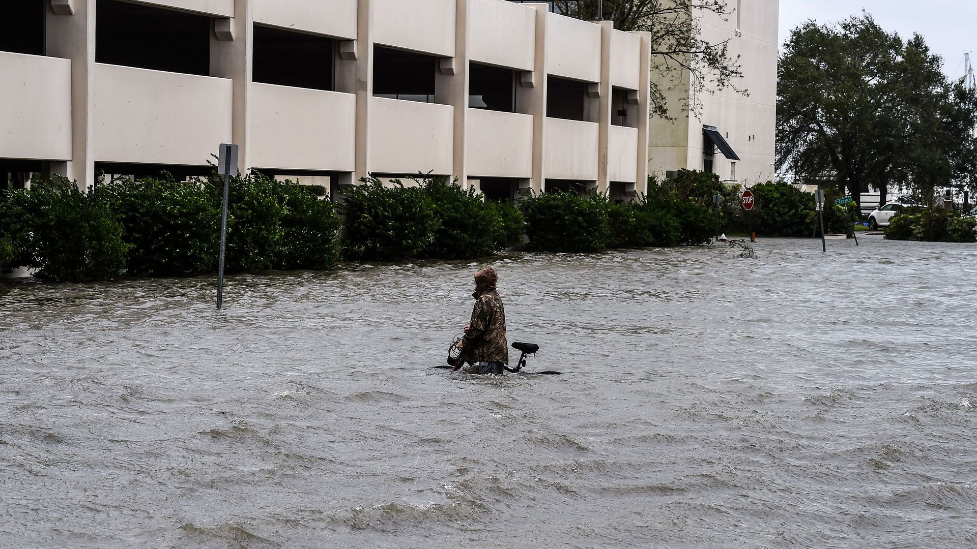A man walks his bicycle through a street flooded by Hurricane Sally in Pensacola, Florida, on September 16