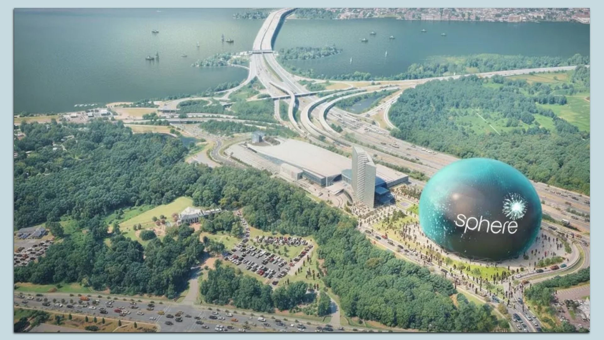 An aerial view of a complex highway interchange beside a wide river, with green parks and a large turquoise sphere labeled sphere near a tall building.