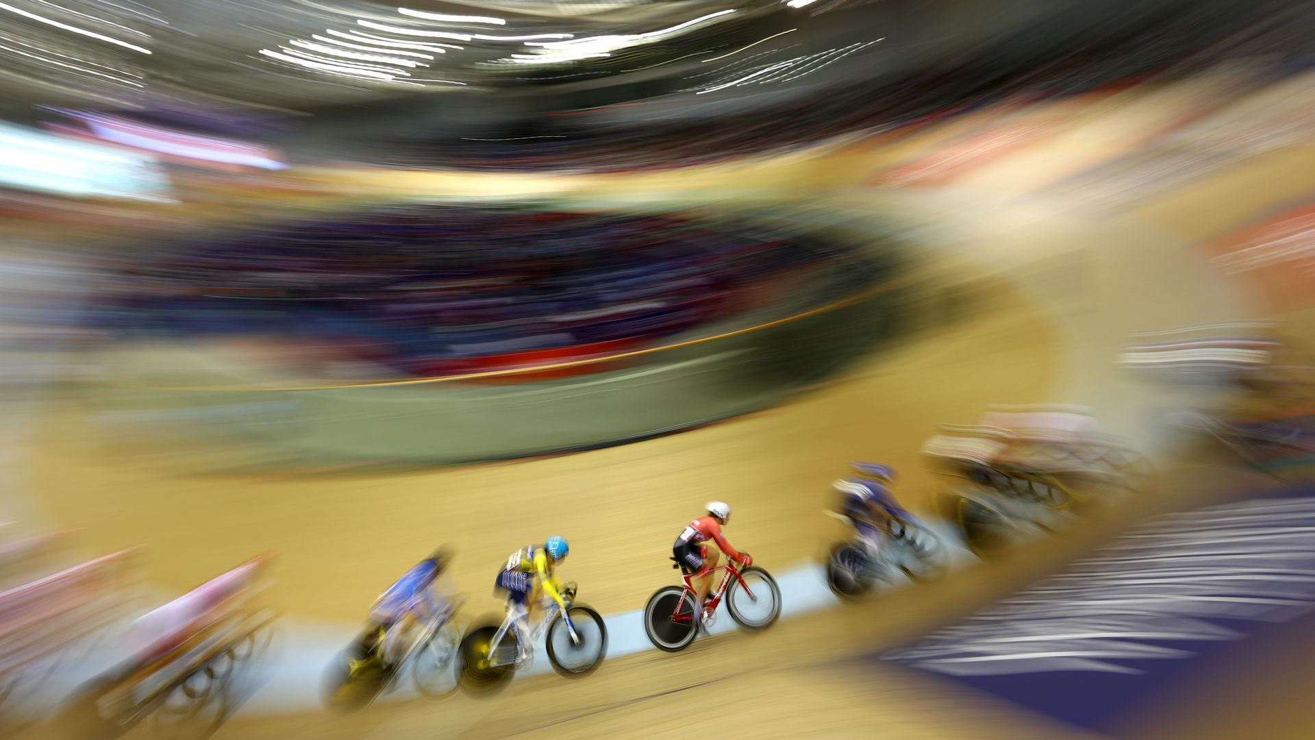 Cyclists whiz by in this blurred image 
