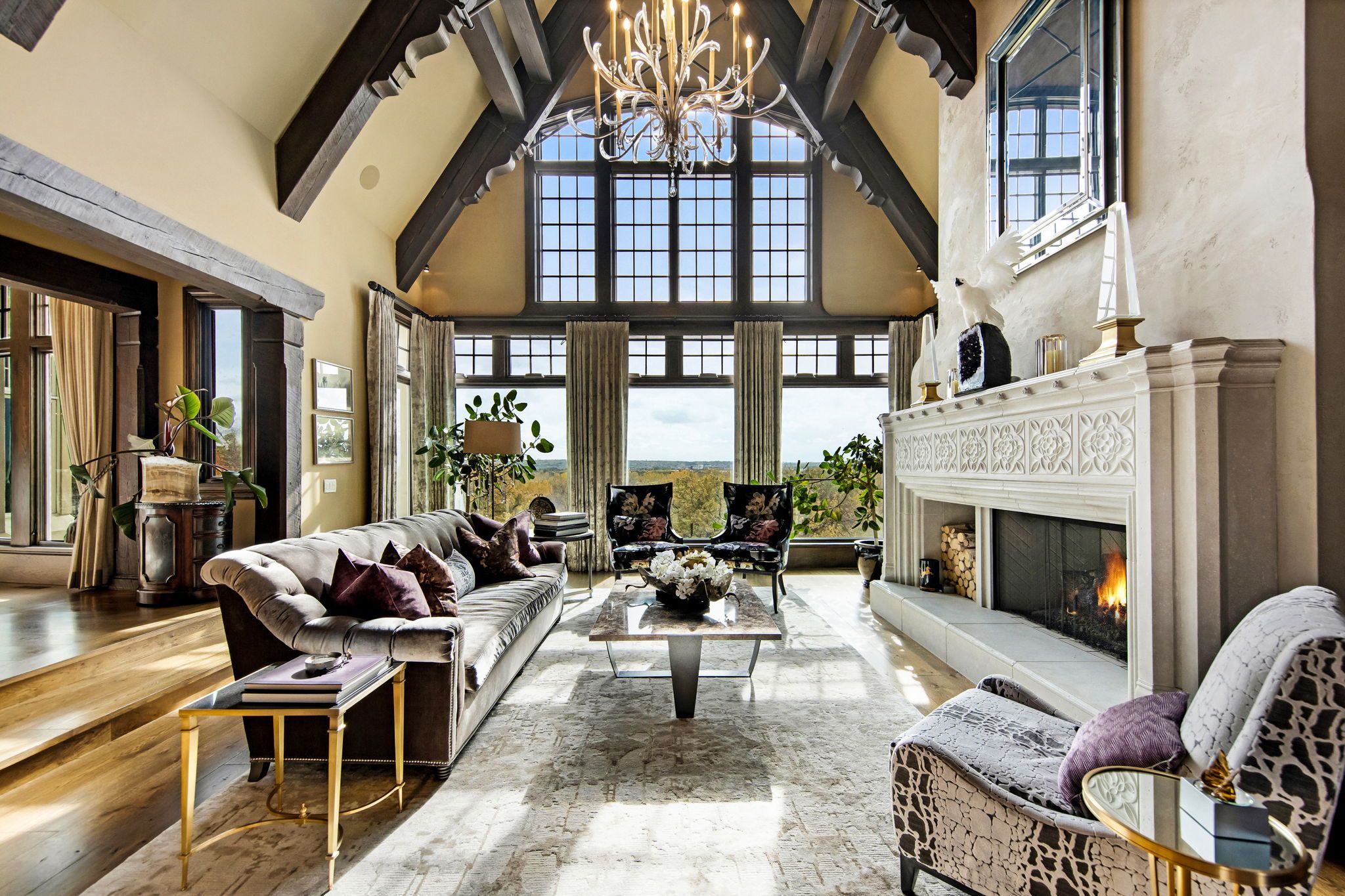 A living room with tall ceilings and a large white fireplace.