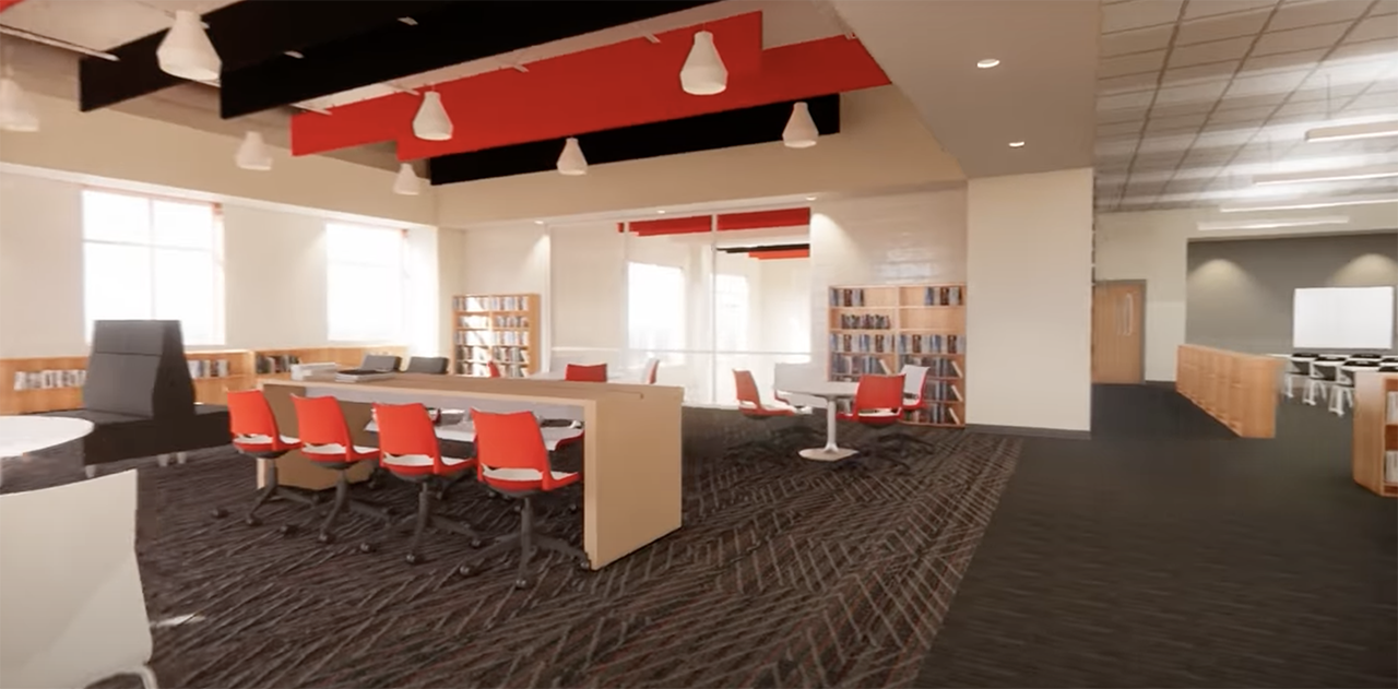 Modern library interior with black and red ceiling lights, red chairs around tables, large windows, wooden bookshelves, and dark patterned carpet.