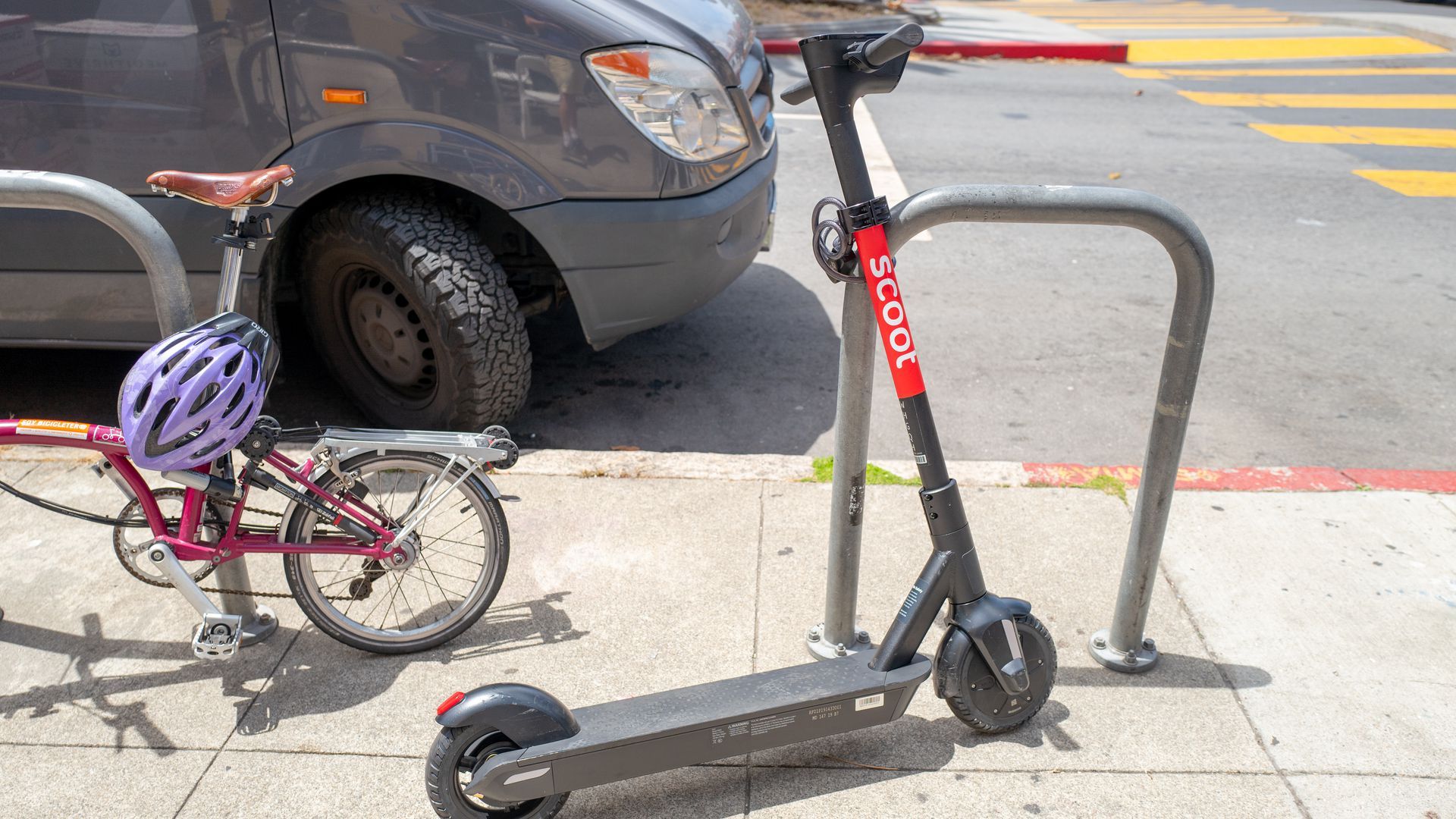 A scooter and a bike on a San Francisco street.