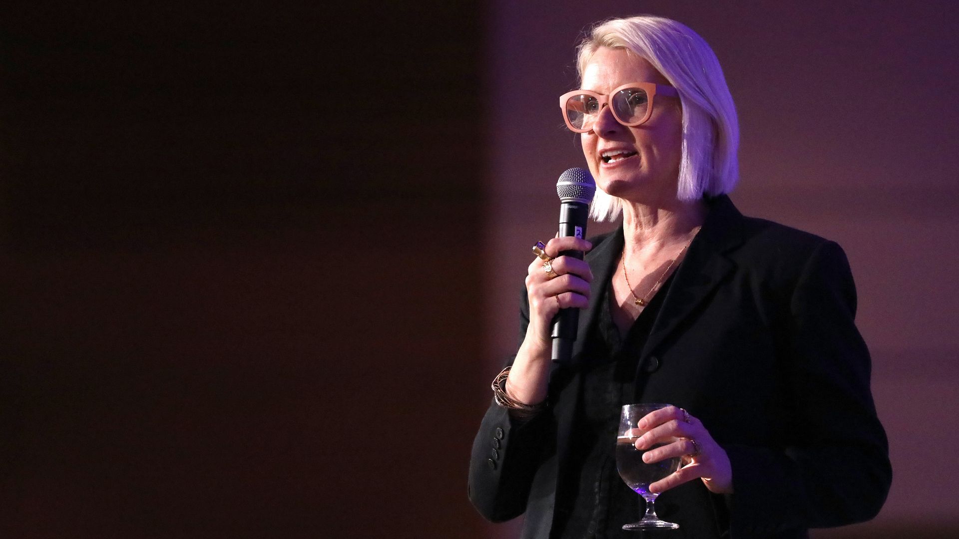 Author Elizabeth Gilbert stands talking into a microphone.