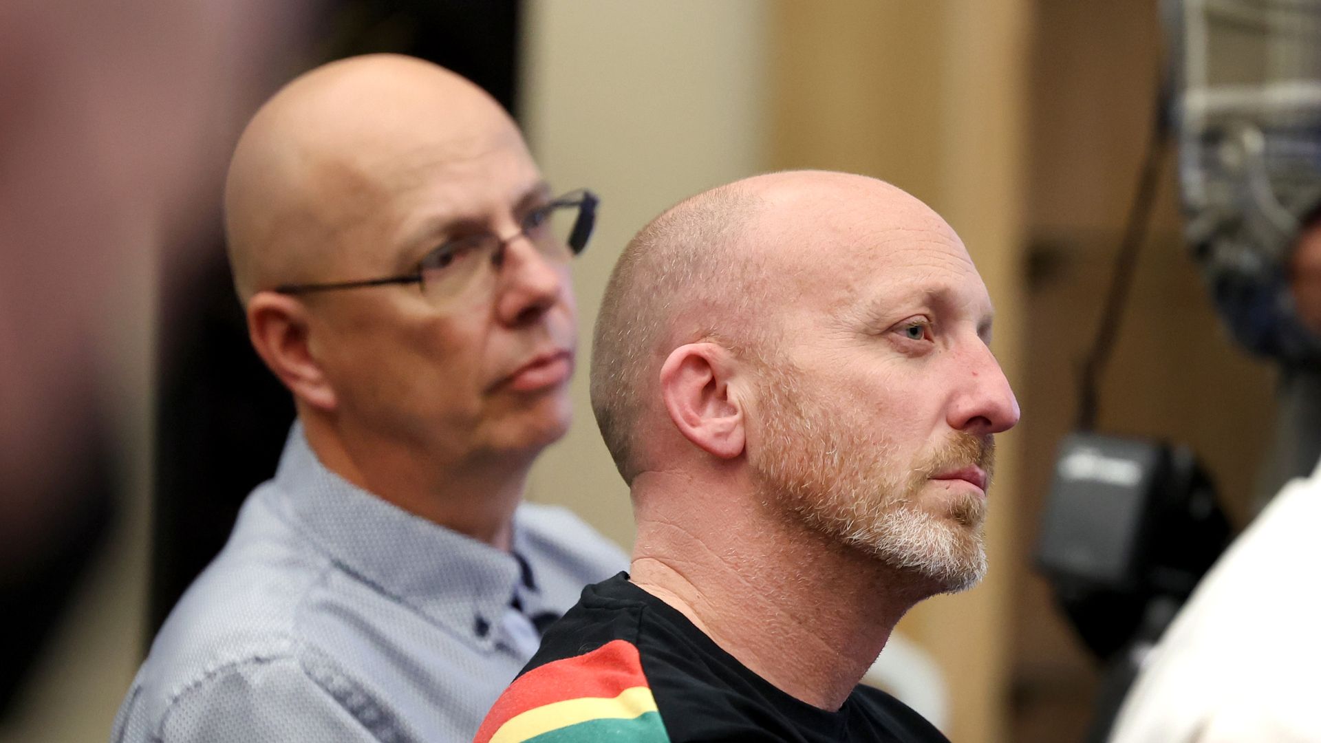 Club Q co-owners Nic Grzecka (R) and Matthew Haynes listen to speakers during a press conference at the Police Operations Center on November 21, 2022 in Colorado Springs, Colorado.