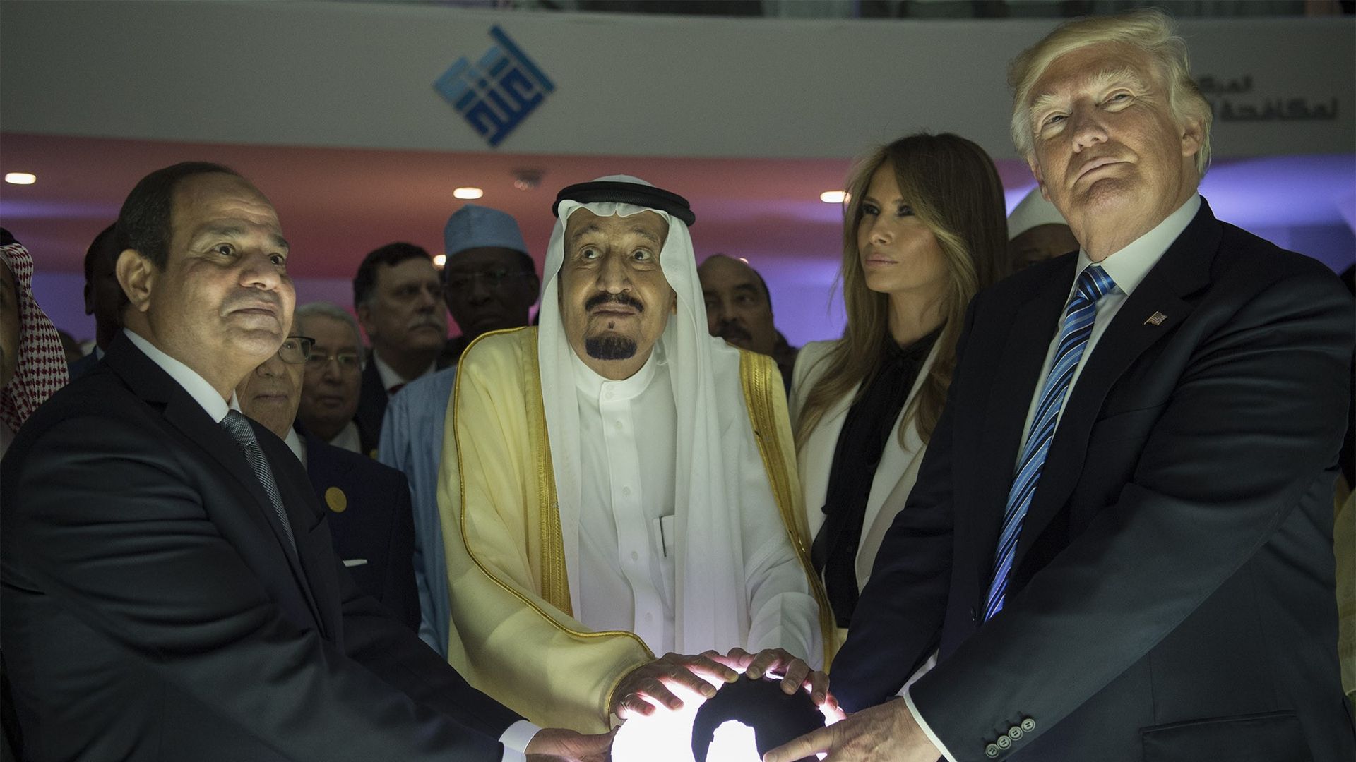 An image of three men, one of which is President-elect Trump, standing with their hands on a glowing orb.