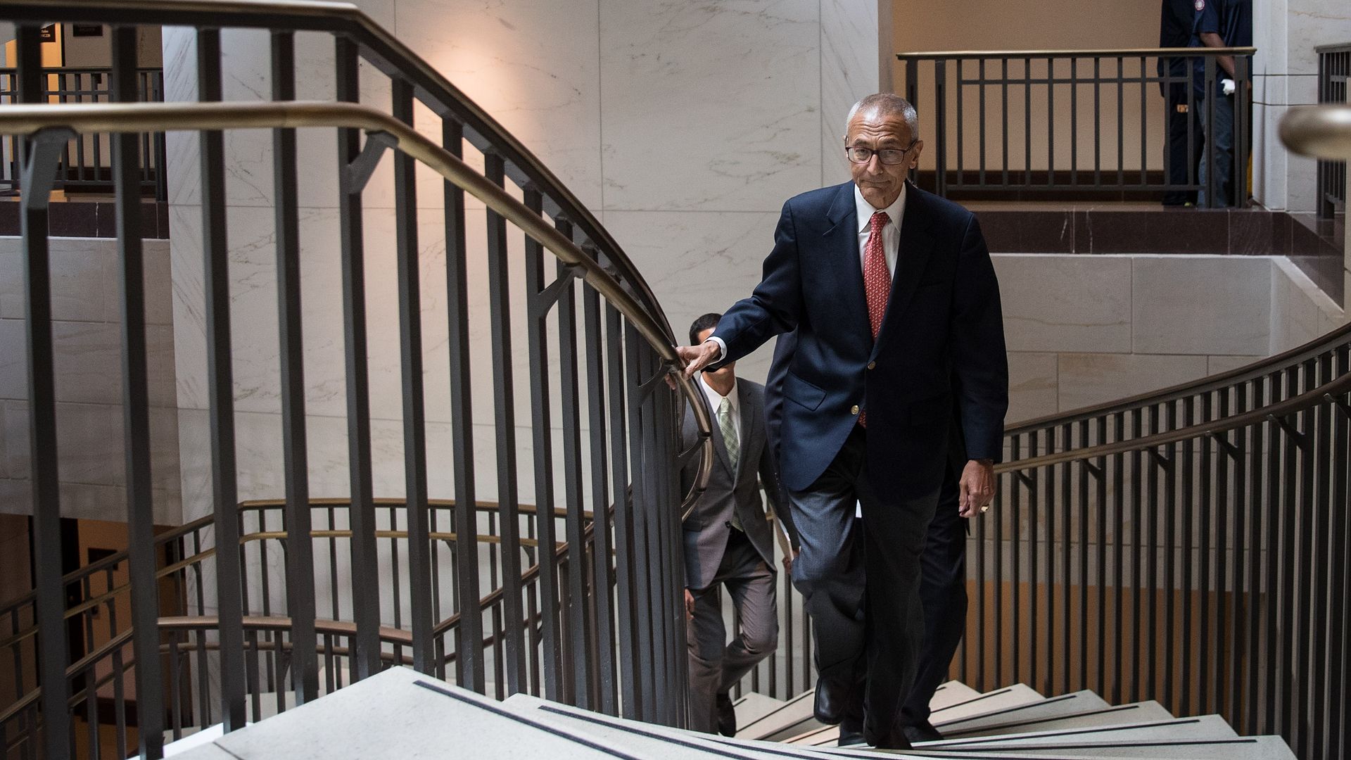 John Podesta is seen walking up a set of stairs in the Capitol Visitors Center.