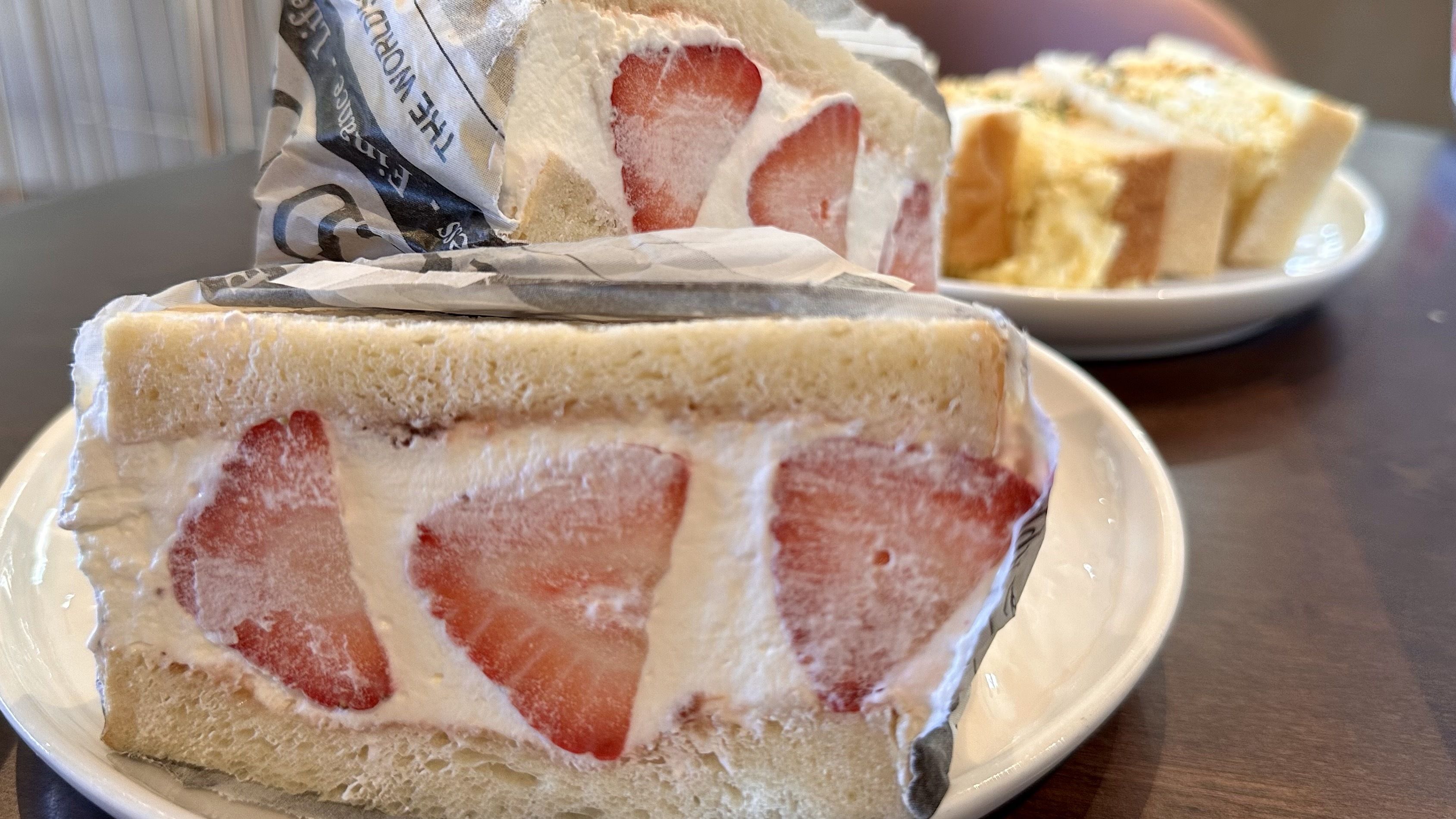 A sandwich with bread, cream and strawberries