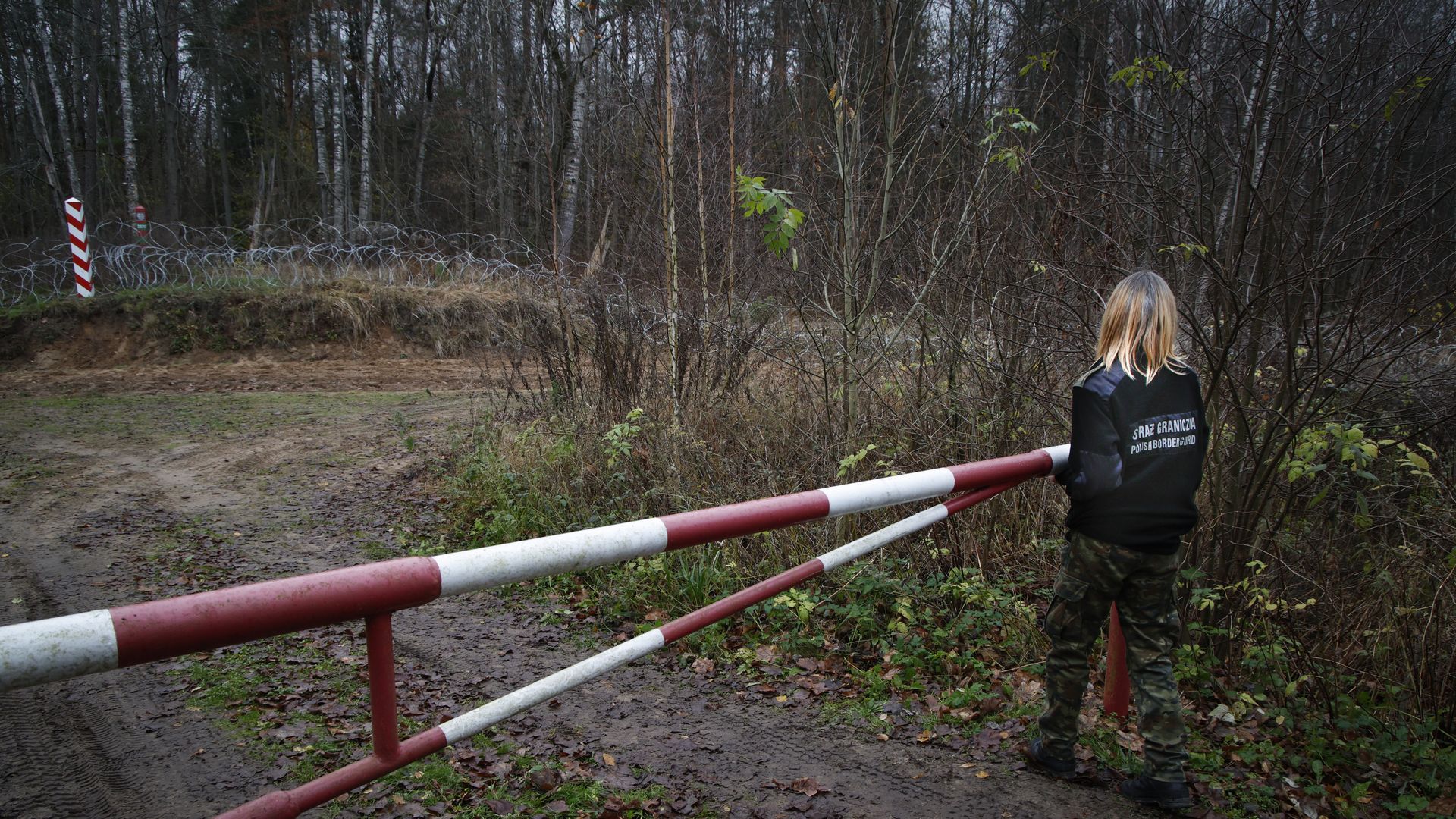 A member of the Polish Border Guards closing a gate leading to the Polish border with the Russian exclave of Kaliningrad near Goldap, Poland, in November, 2022.