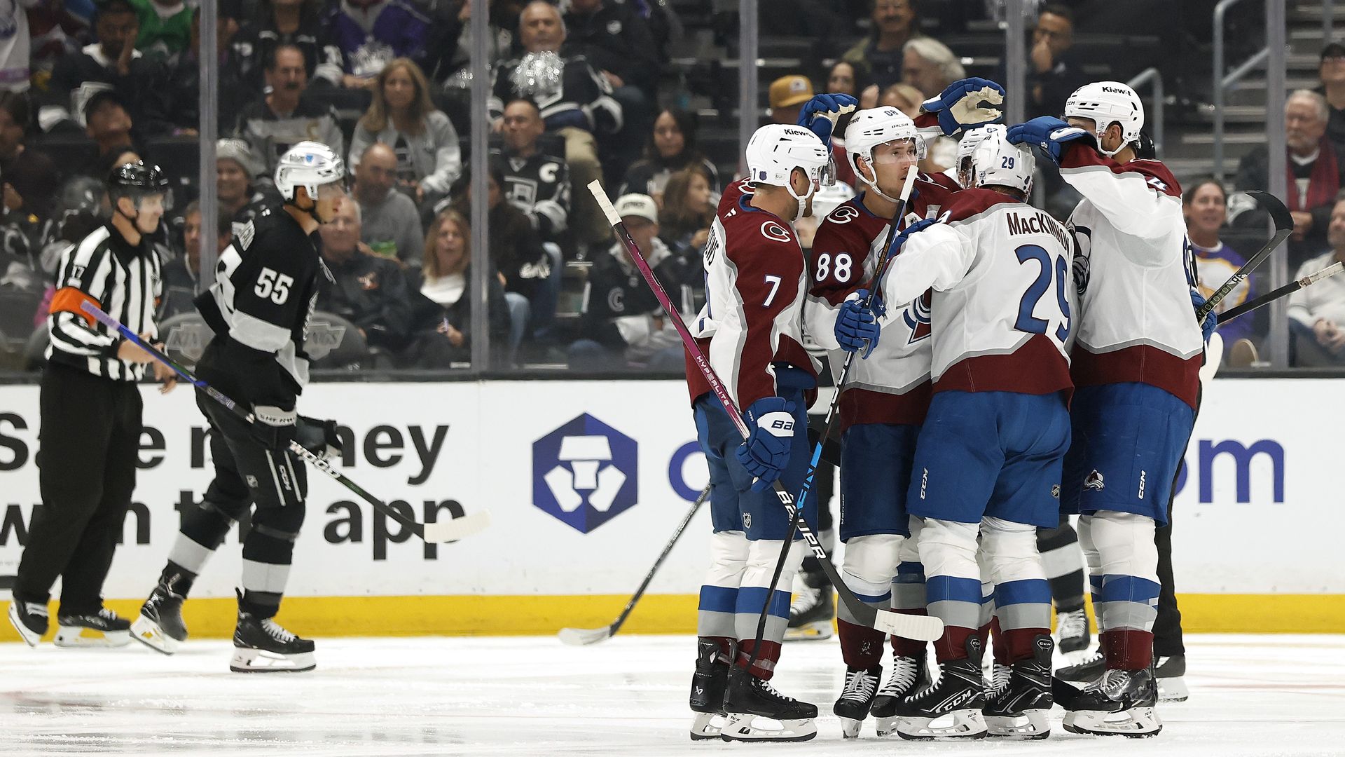 Several men in hockey uniforms celebrate by patting each other.