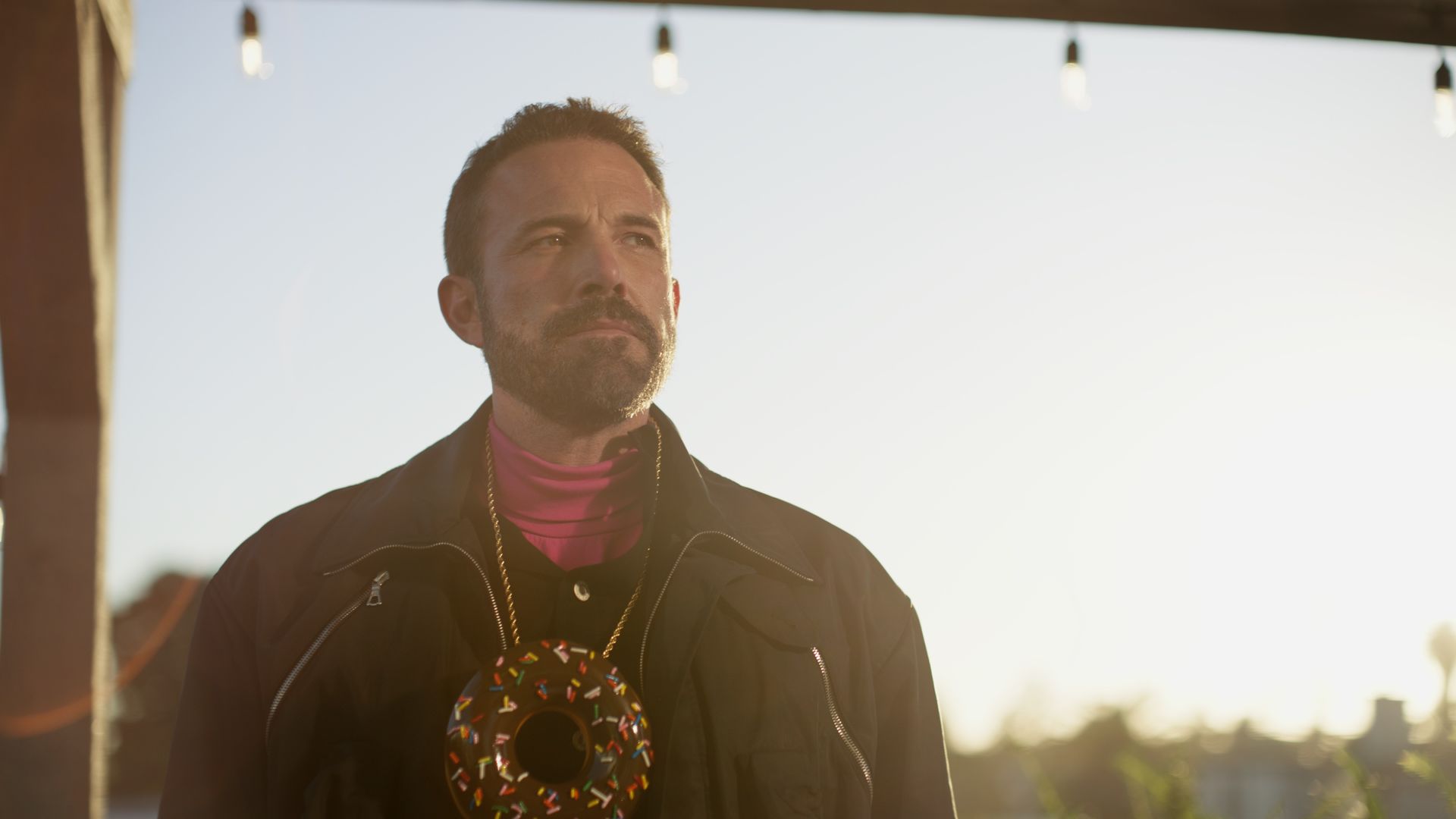 Ben Affleck stares off into the distance in a new Dunkin' ad, as he wears a gold chain with a doughnut necklace.