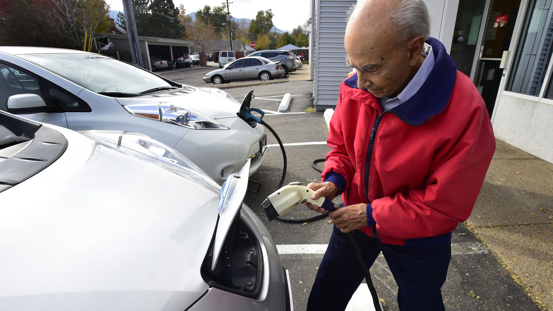 Man charging an electric car in public