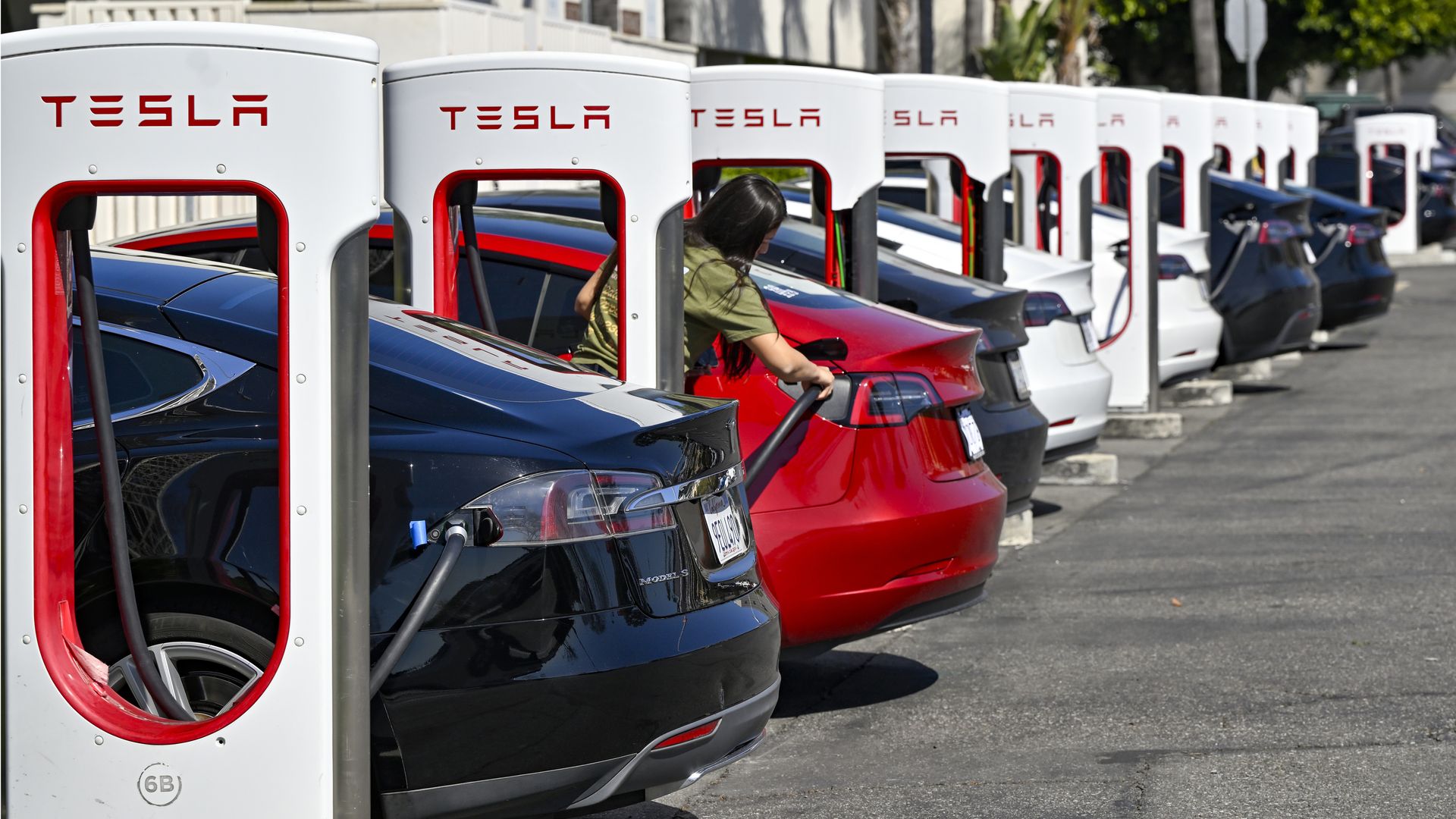 Tesla's in a line at a Tesla charging station.
