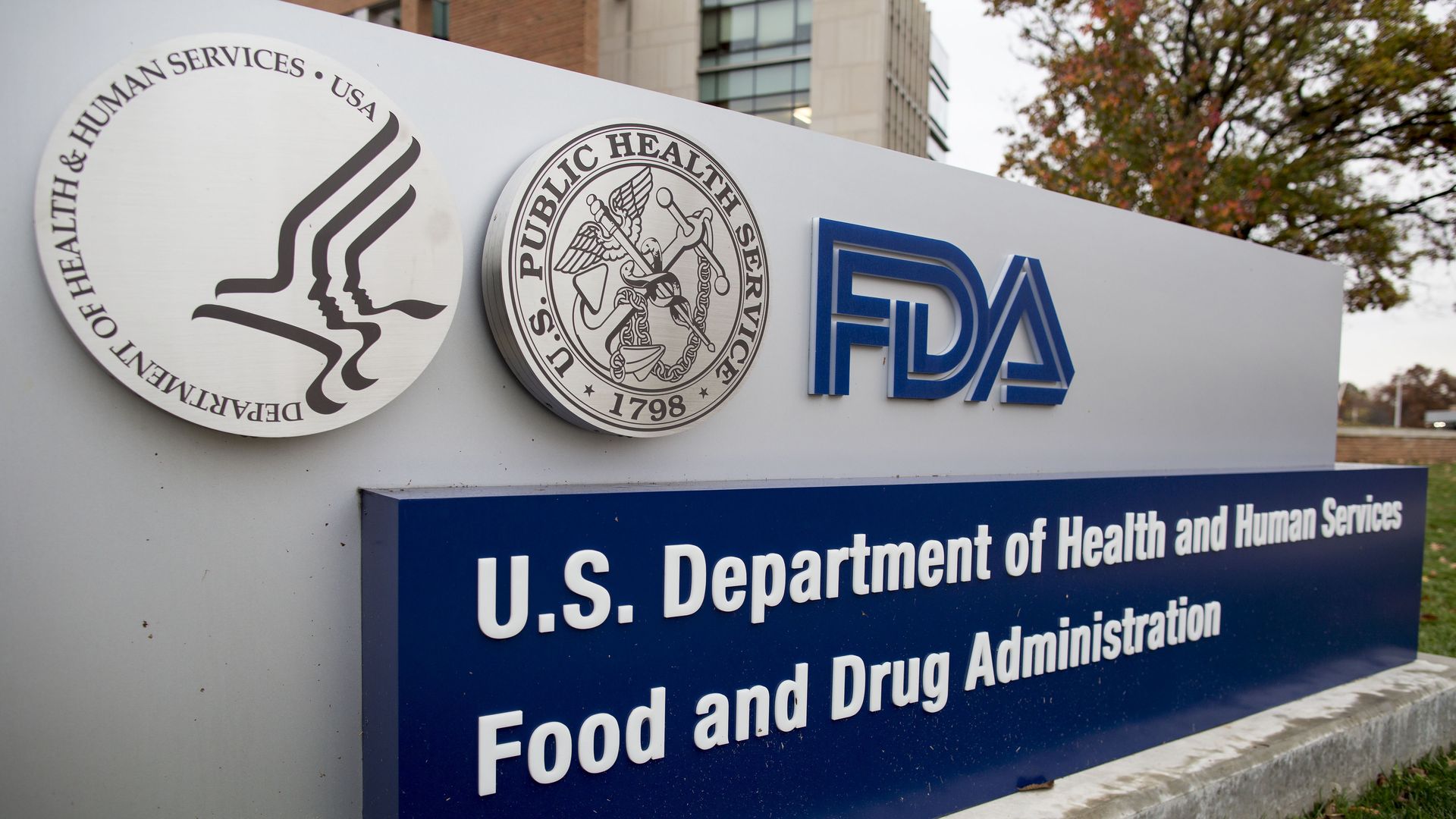 In this image, a sign displays the FDA and HHS logos